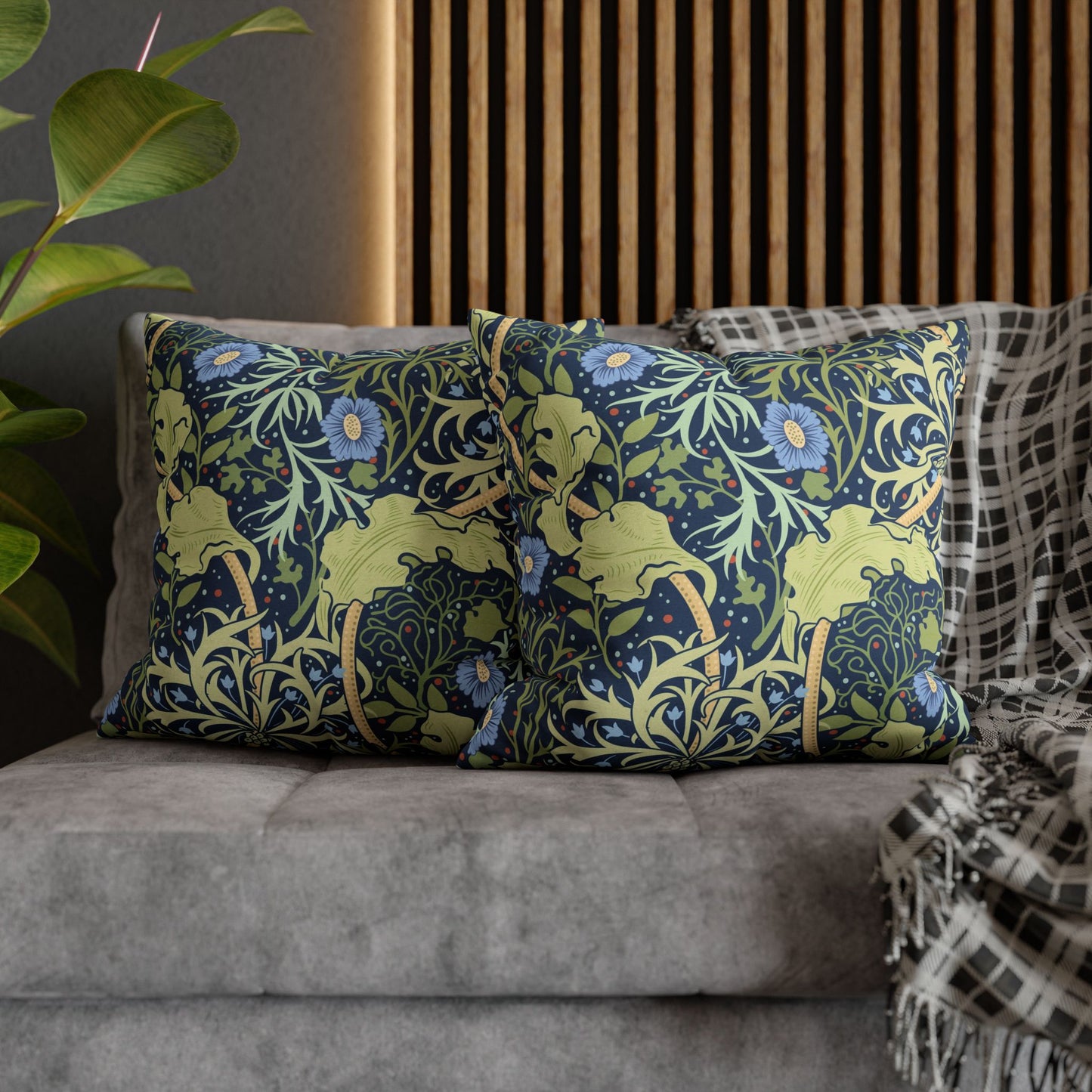 Decorative pillows with floral patterns on a gray sofa.
