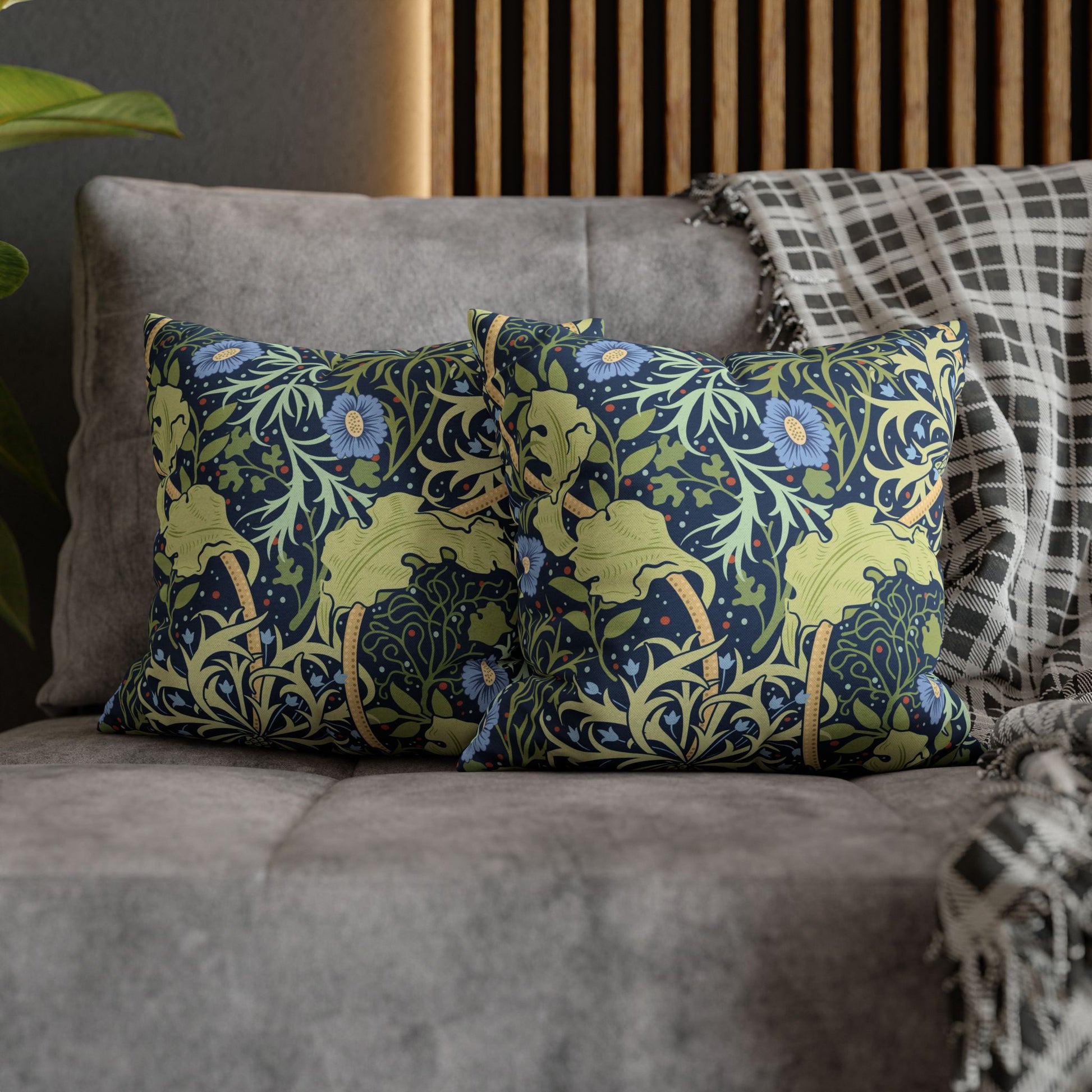 Decorative pillows with floral and animal pattern on a gray sofa.