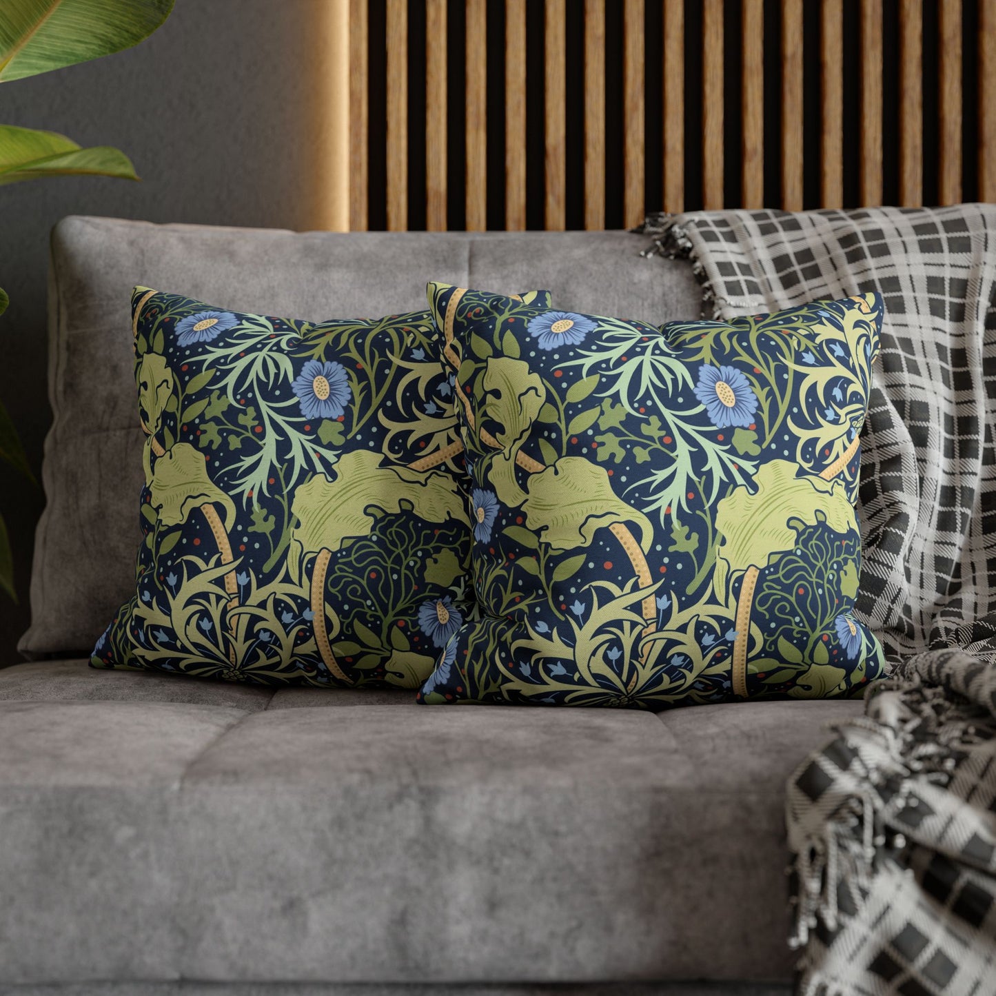 Decorative pillows with floral patterns on a gray sofa.