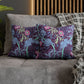 Decorative pillows with floral and elephant pattern on a gray sofa.