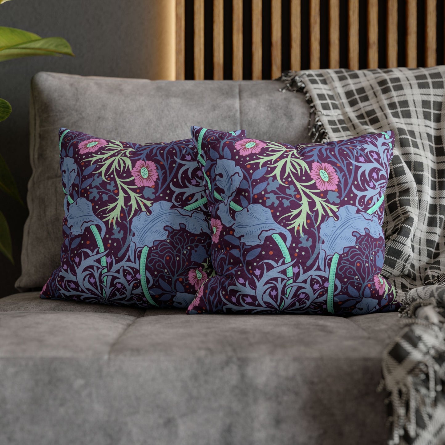 Decorative pillows with floral and elephant pattern on a gray sofa.