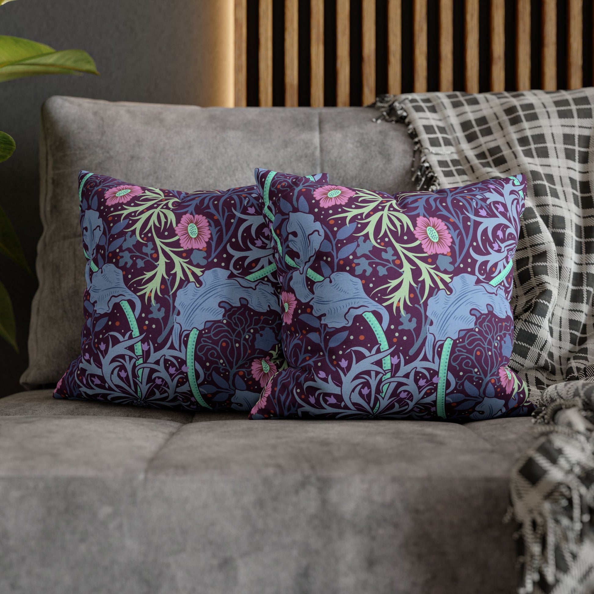 Decorative pillows with floral and elephant pattern on a gray sofa.