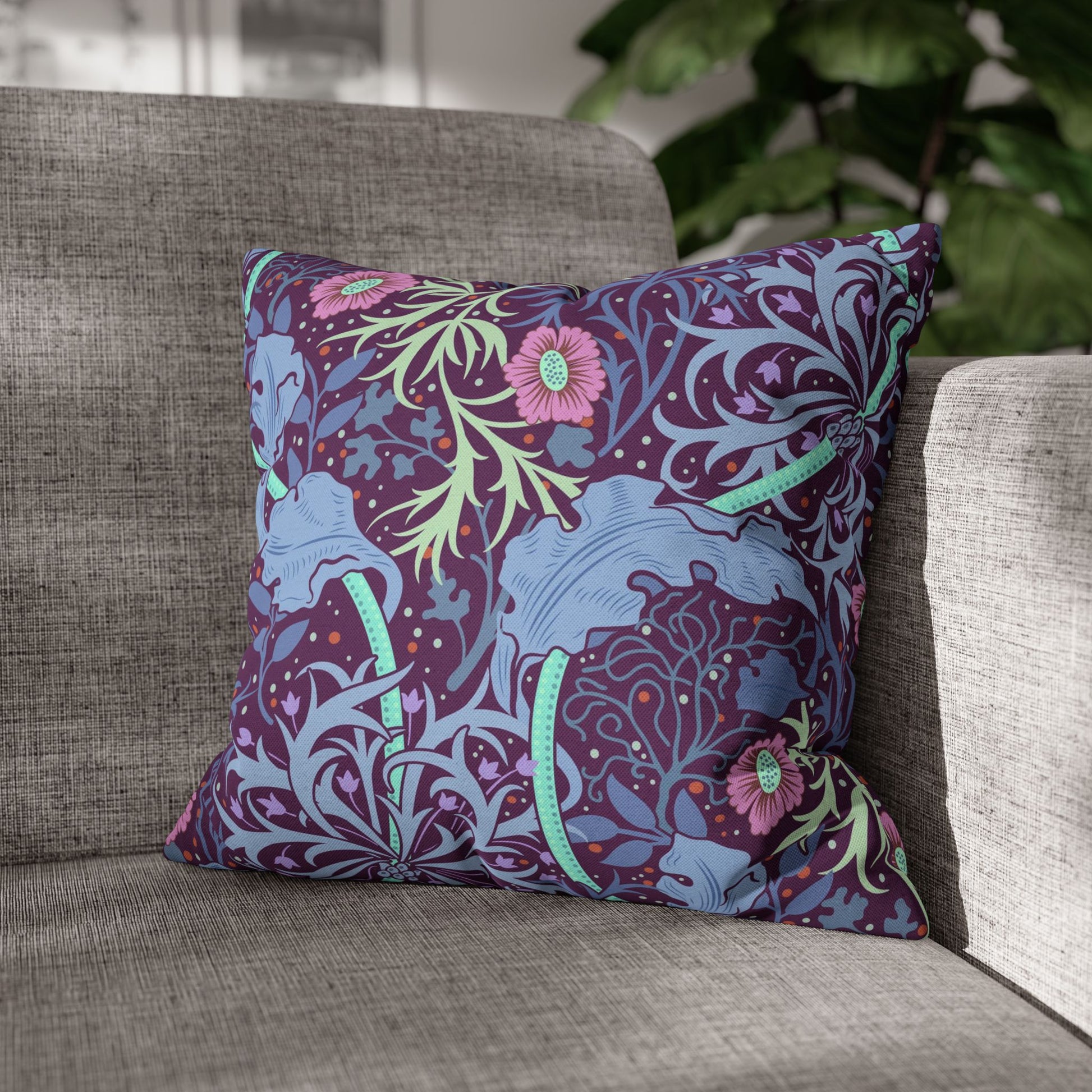 Decorative pillow with floral and animal pattern on a gray sofa