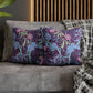 Decorative pillows with floral and elephant pattern on a sofa.