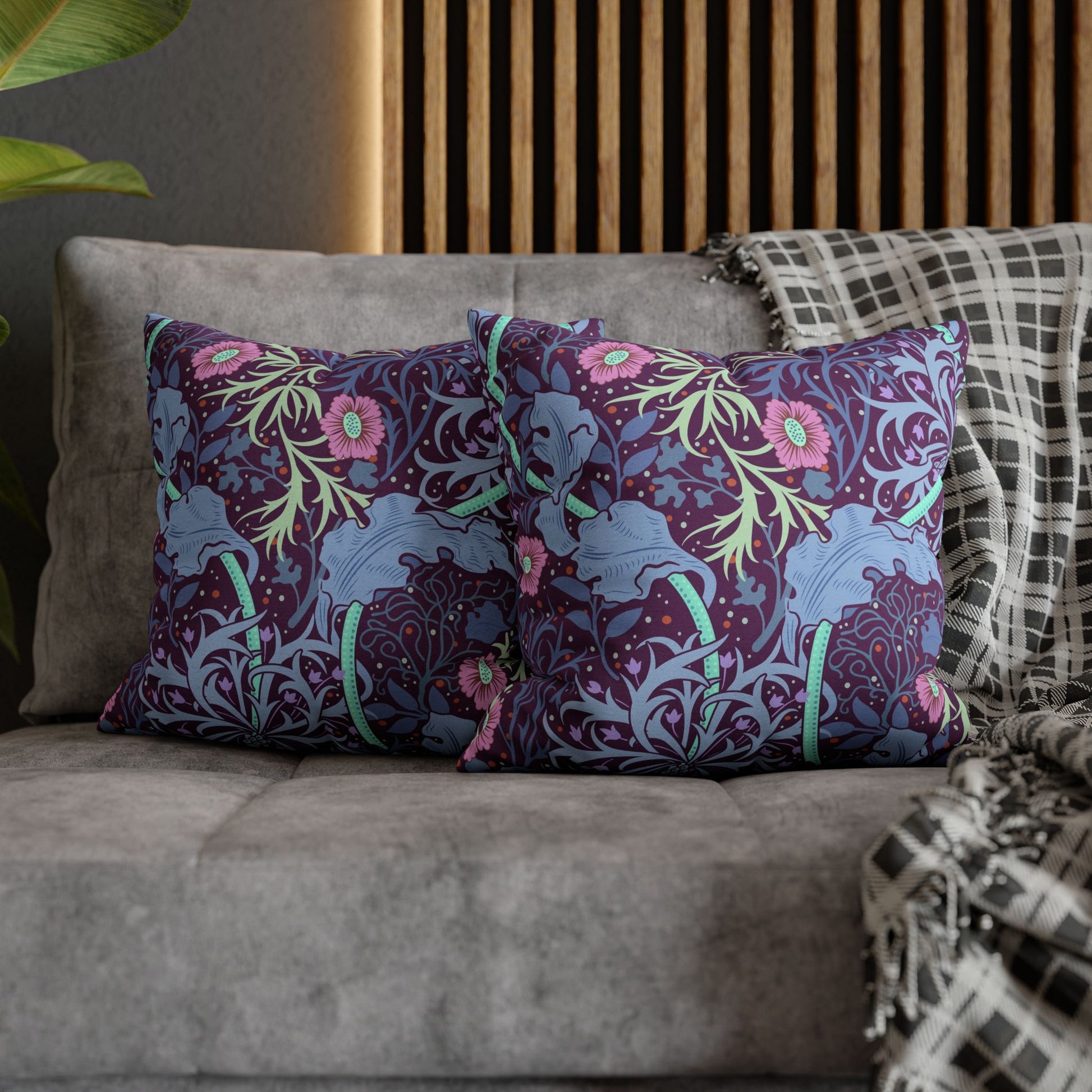 Decorative pillows with floral and elephant pattern on a sofa.