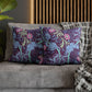 Decorative pillows with floral pattern on a sofa against a wooden panel background