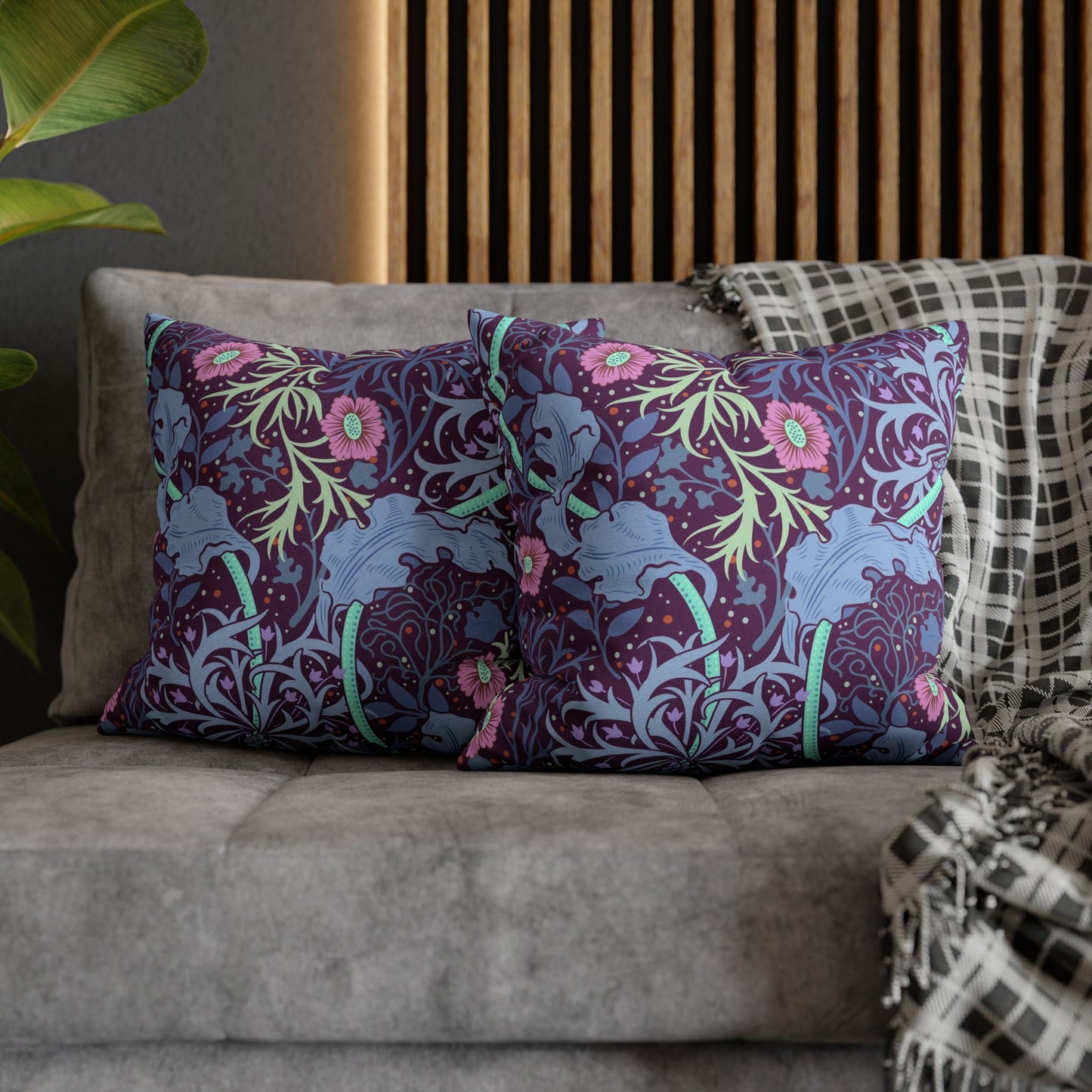 Decorative pillows with floral pattern on a sofa against a wooden panel background