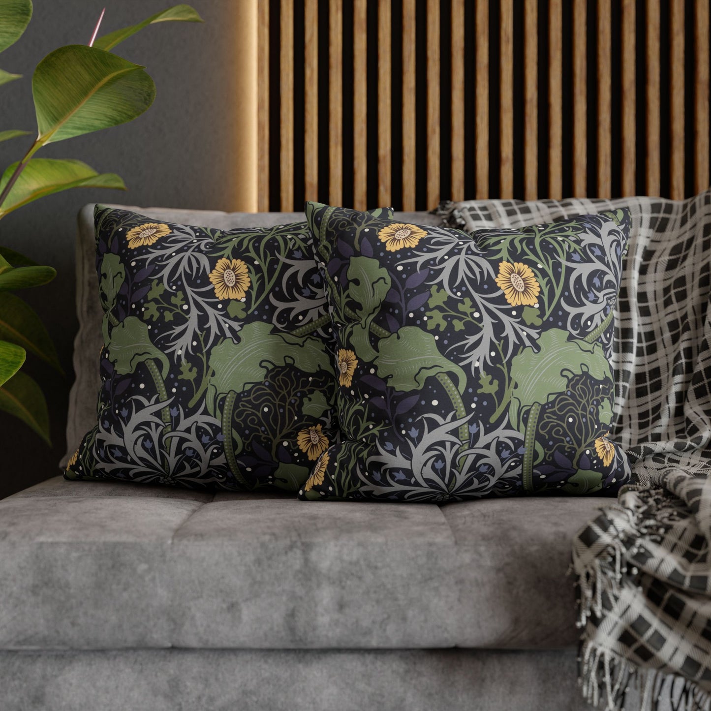 Decorative pillows with floral patterns on a gray sofa against a wooden slat wall.