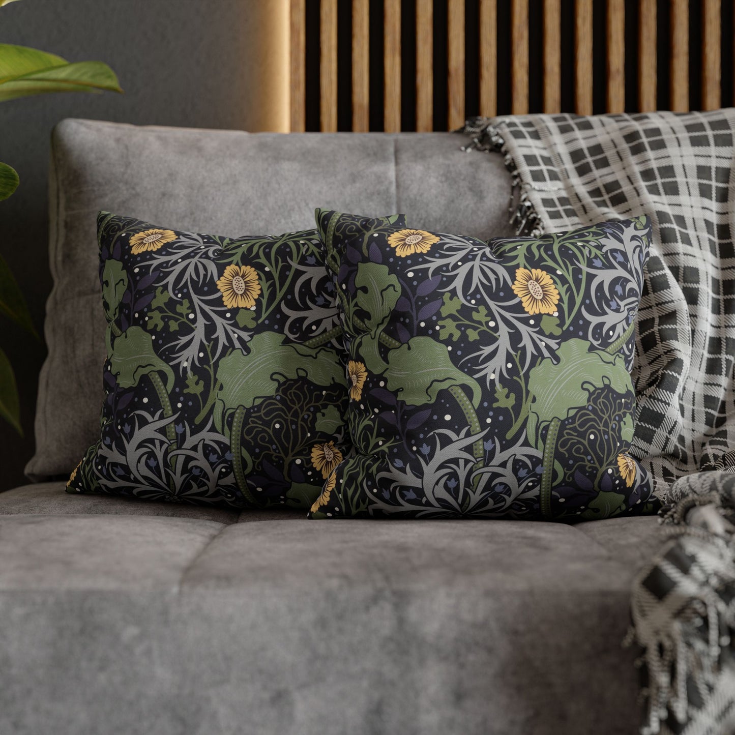 Decorative pillows with floral and animal pattern on a gray sofa.