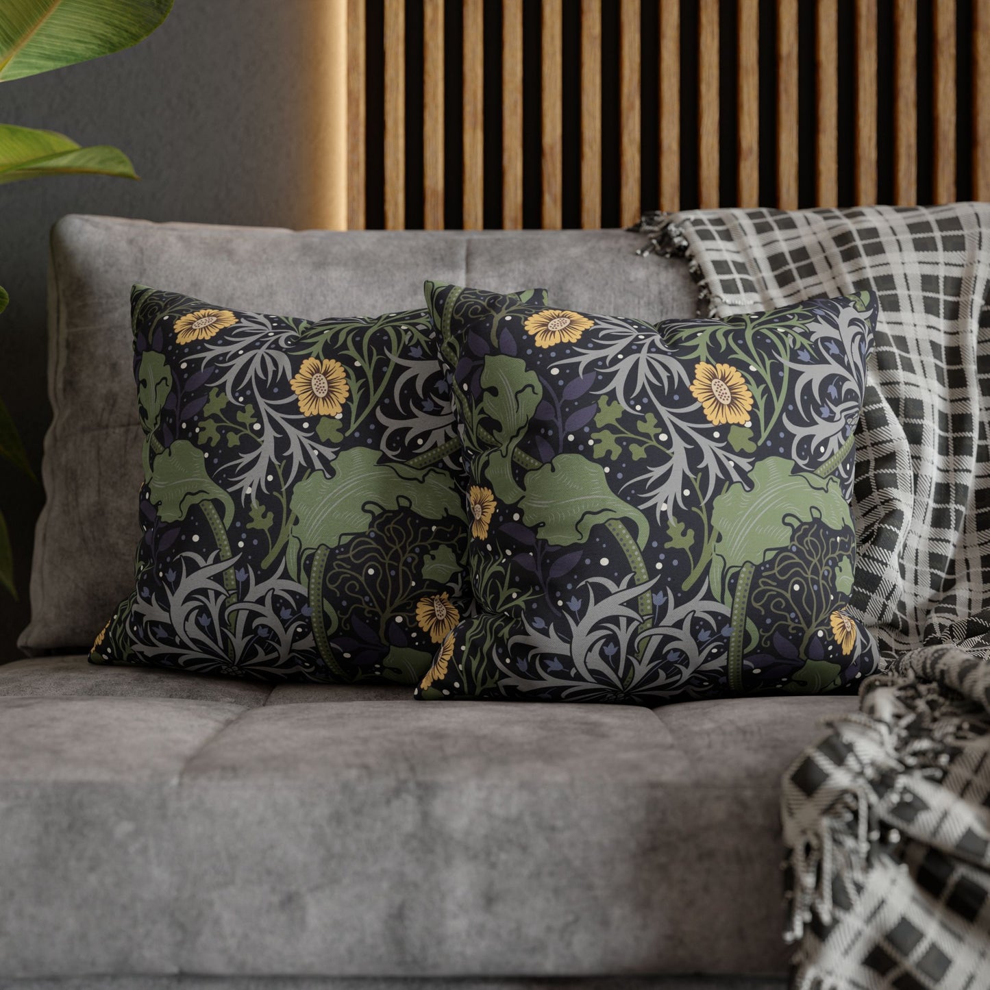 Decorative pillows with nature-themed patterns on a gray sofa.