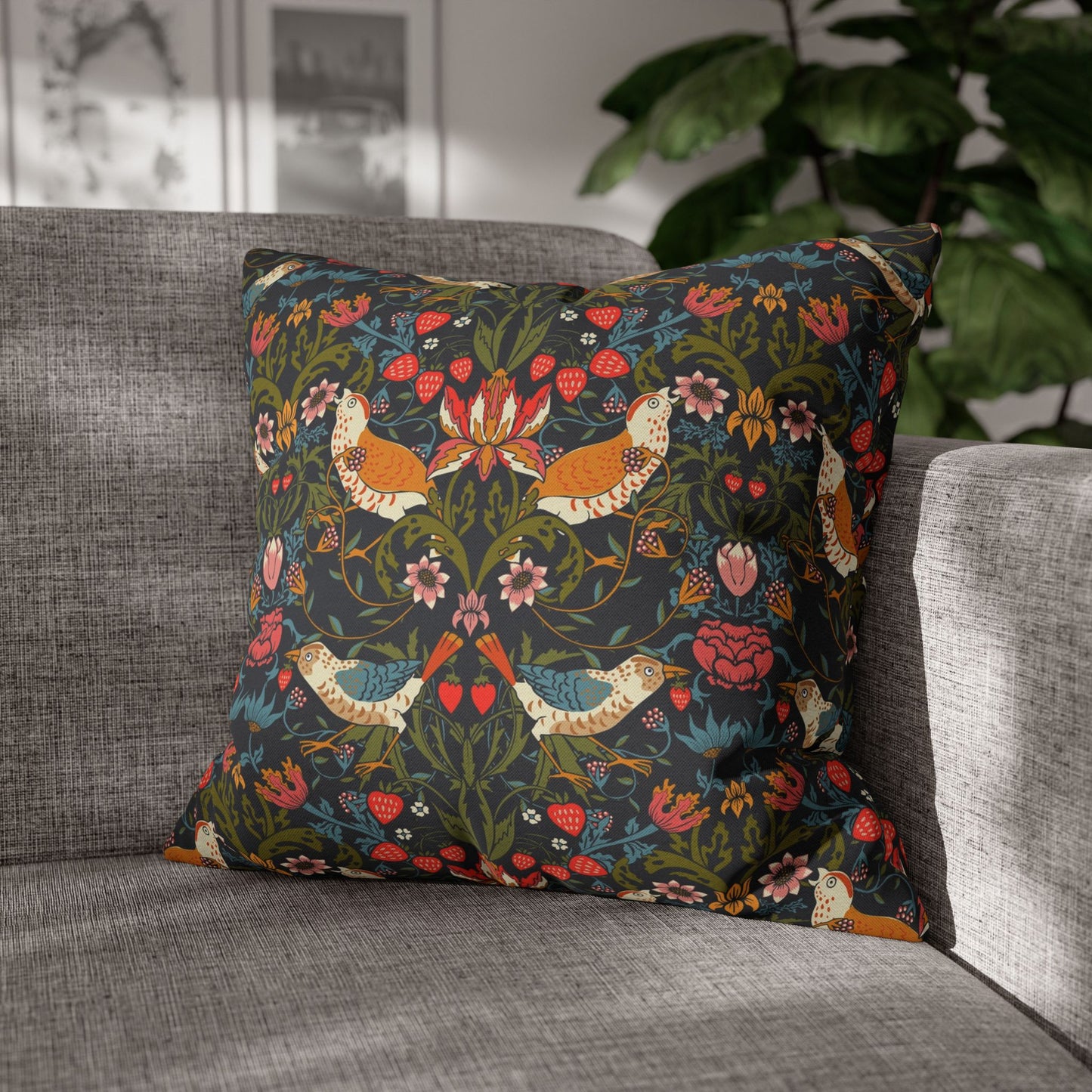 Decorative pillow with floral and bird pattern on a gray sofa