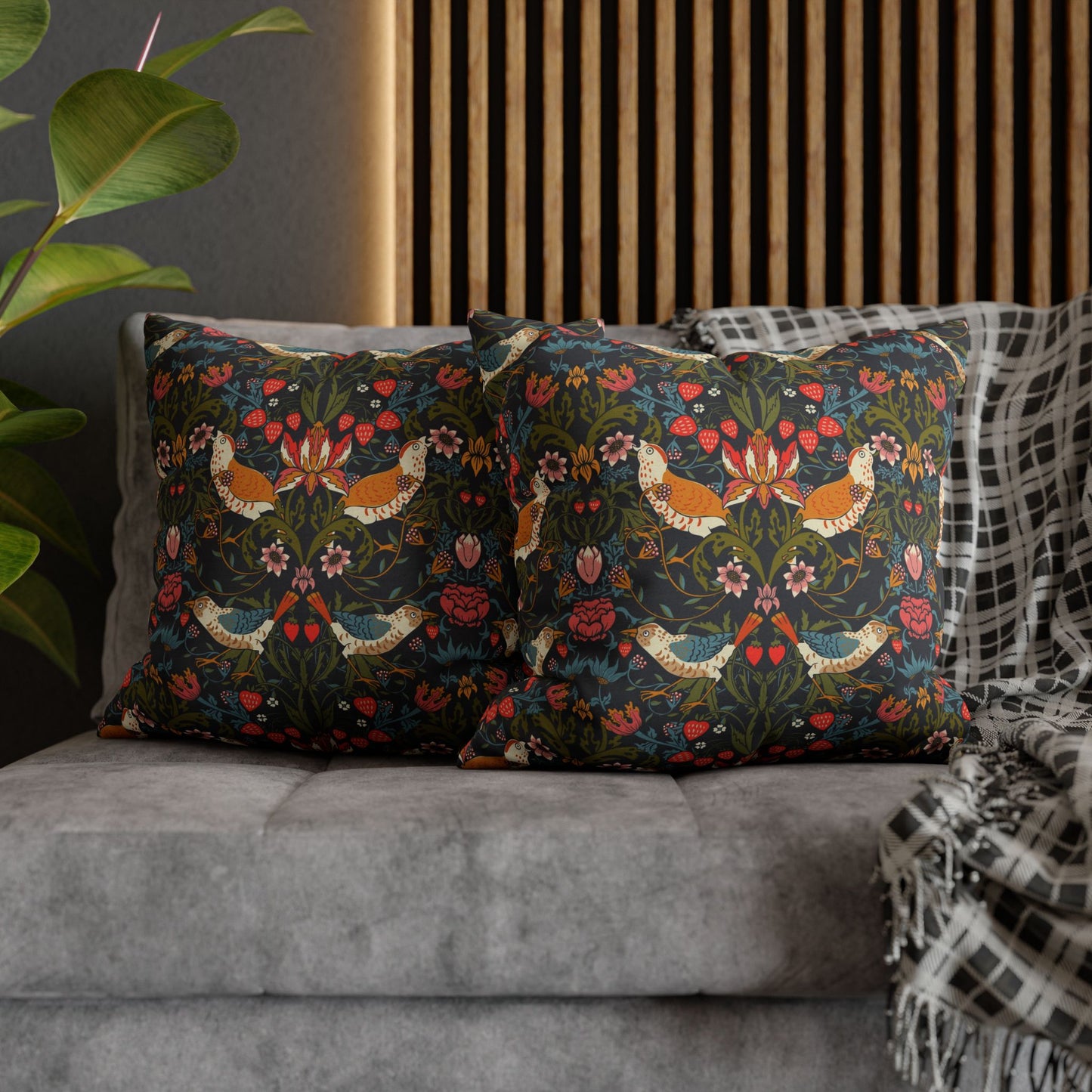 Decorative pillows with floral patterns on a gray sofa.