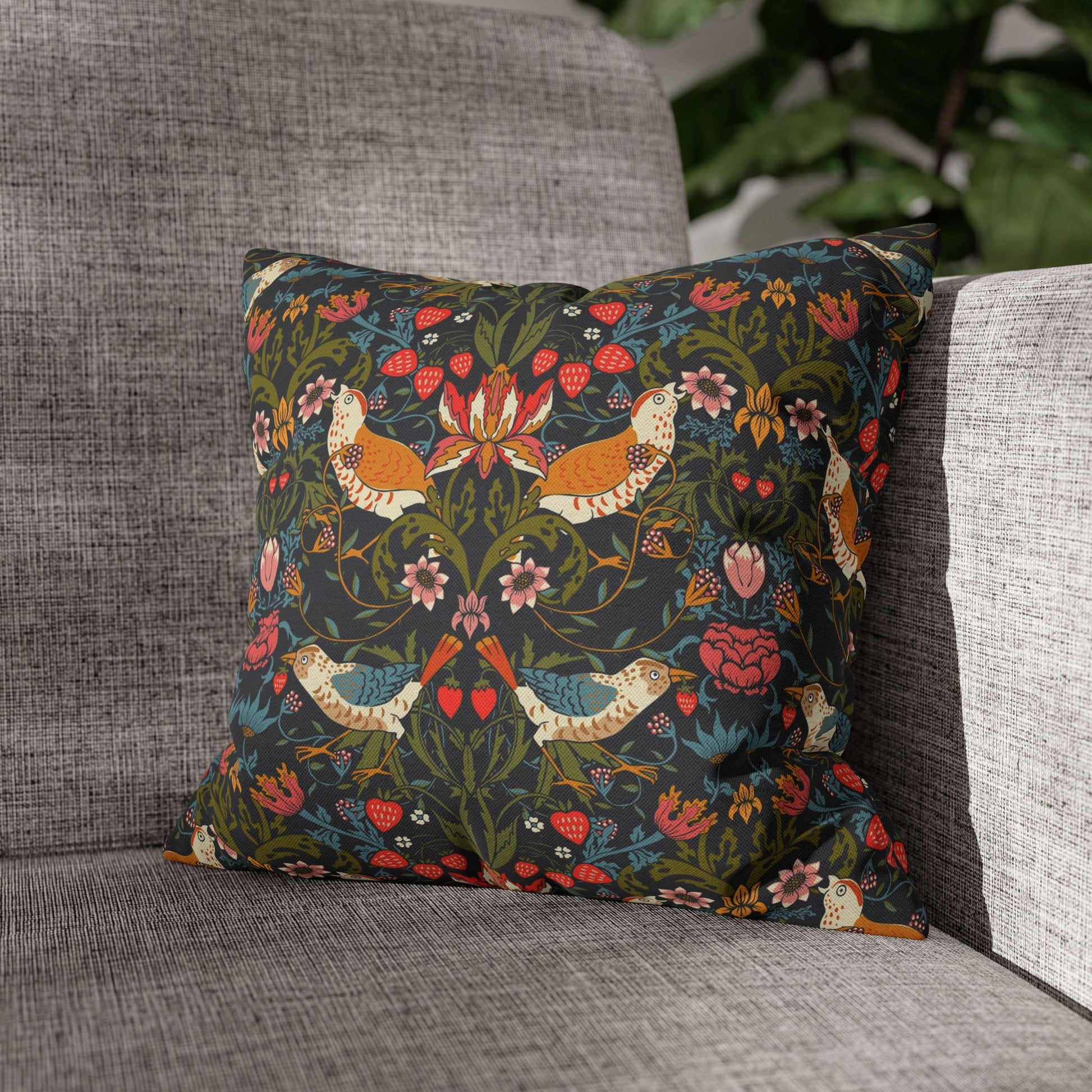 Decorative pillow with floral and bird pattern on a gray sofa