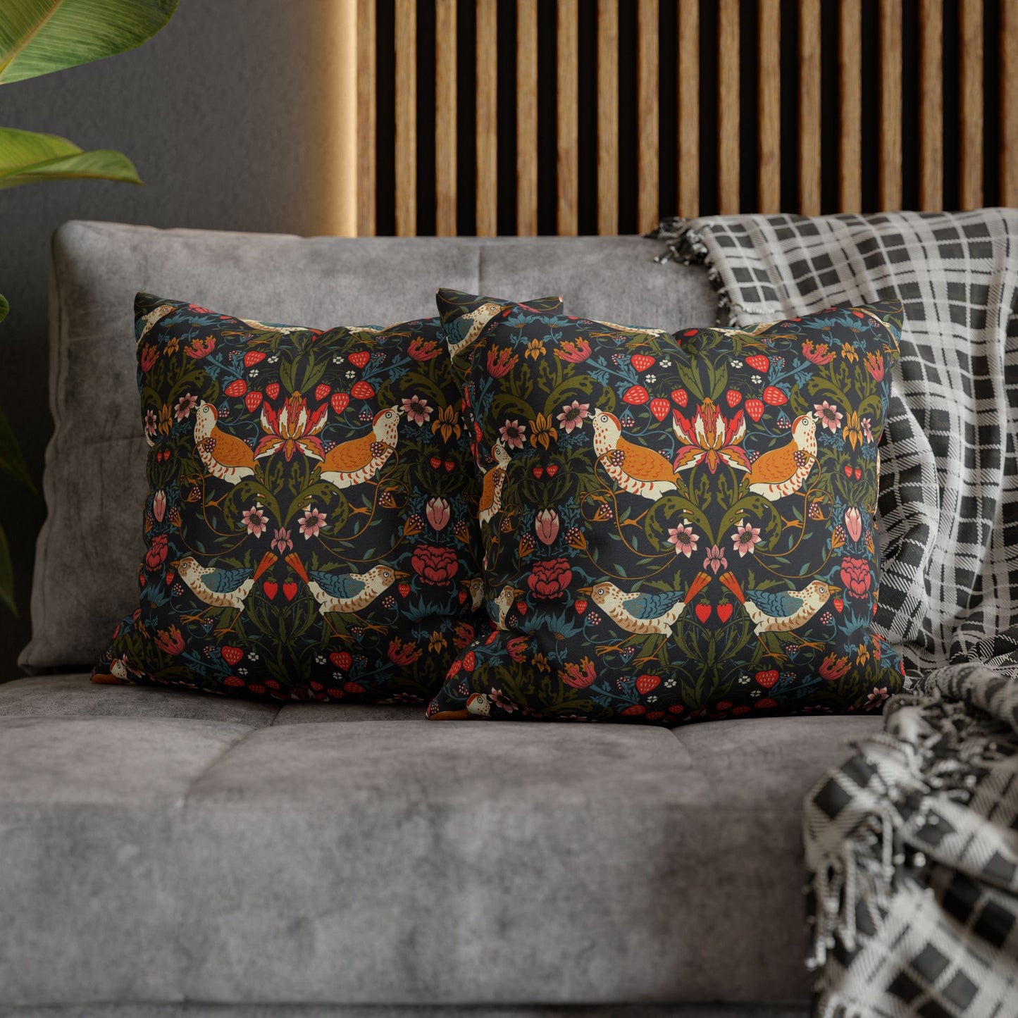 Decorative pillows with floral patterns on a gray sofa.