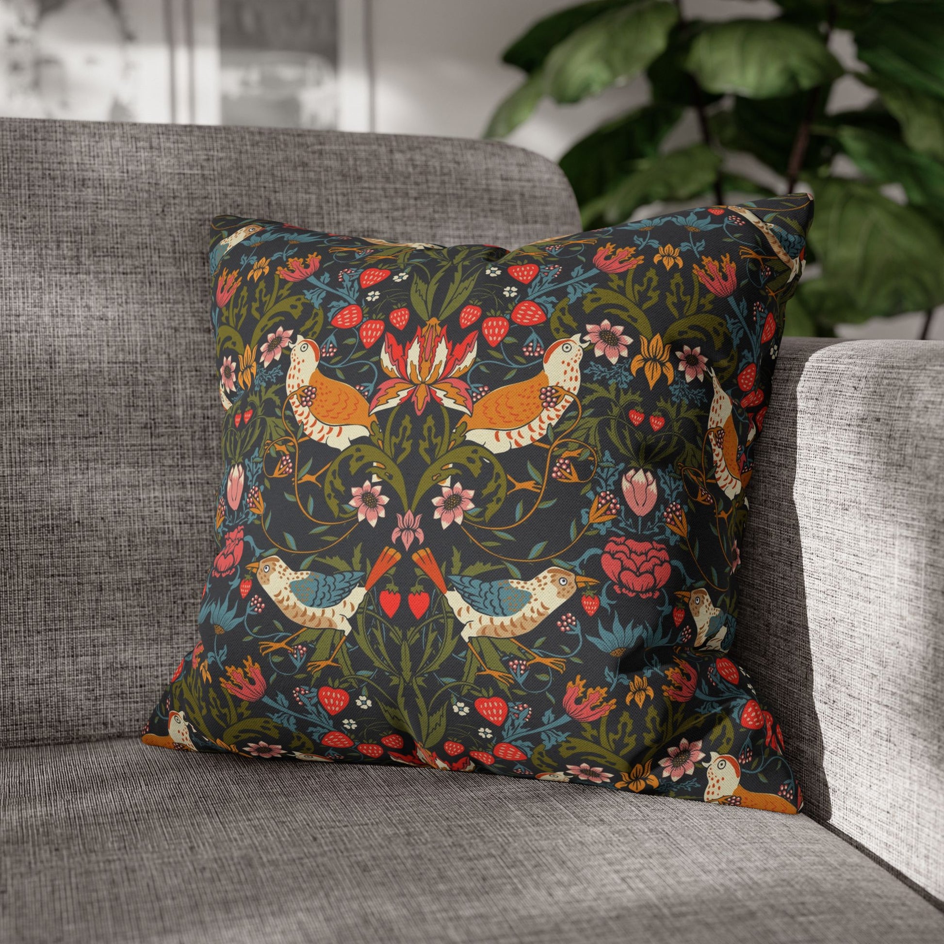 Decorative pillow with floral and bird pattern on a gray sofa
