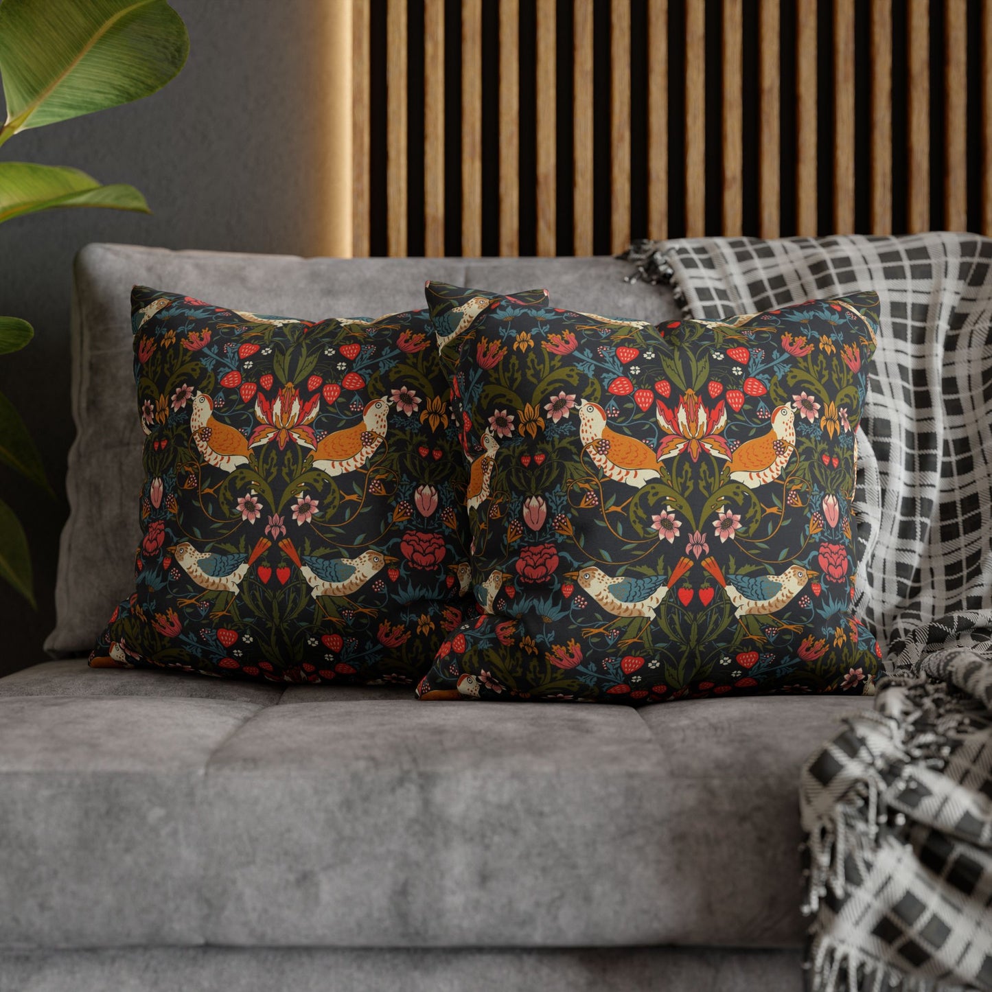Decorative pillows with floral patterns on a gray sofa against a wooden headboard.