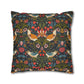 Decorative pillow with intricate floral and bird pattern on a dark background