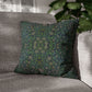 Green patterned pillow on a gray sofa with a blurred plant in the background