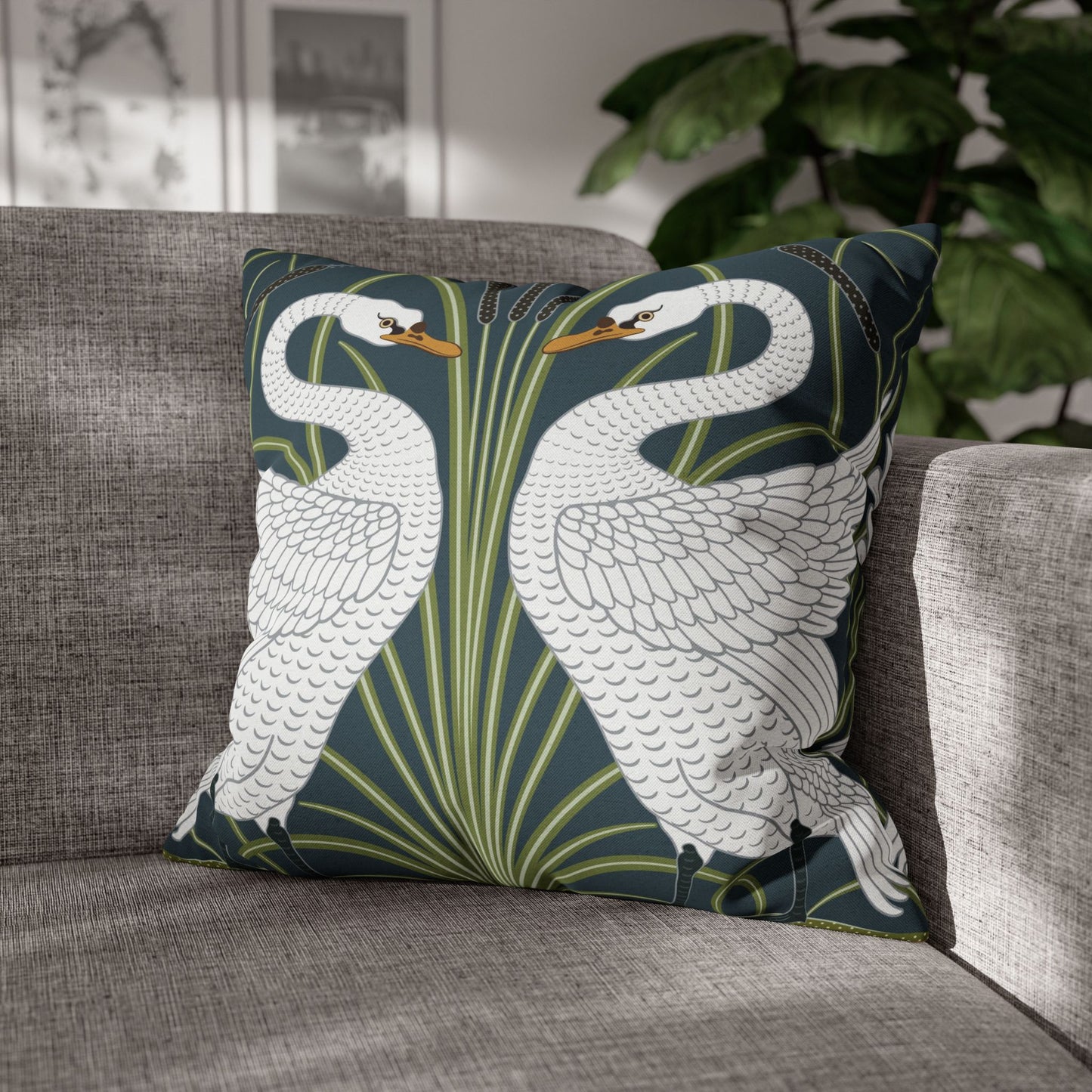 Decorative pillow with swan design on a gray sofa