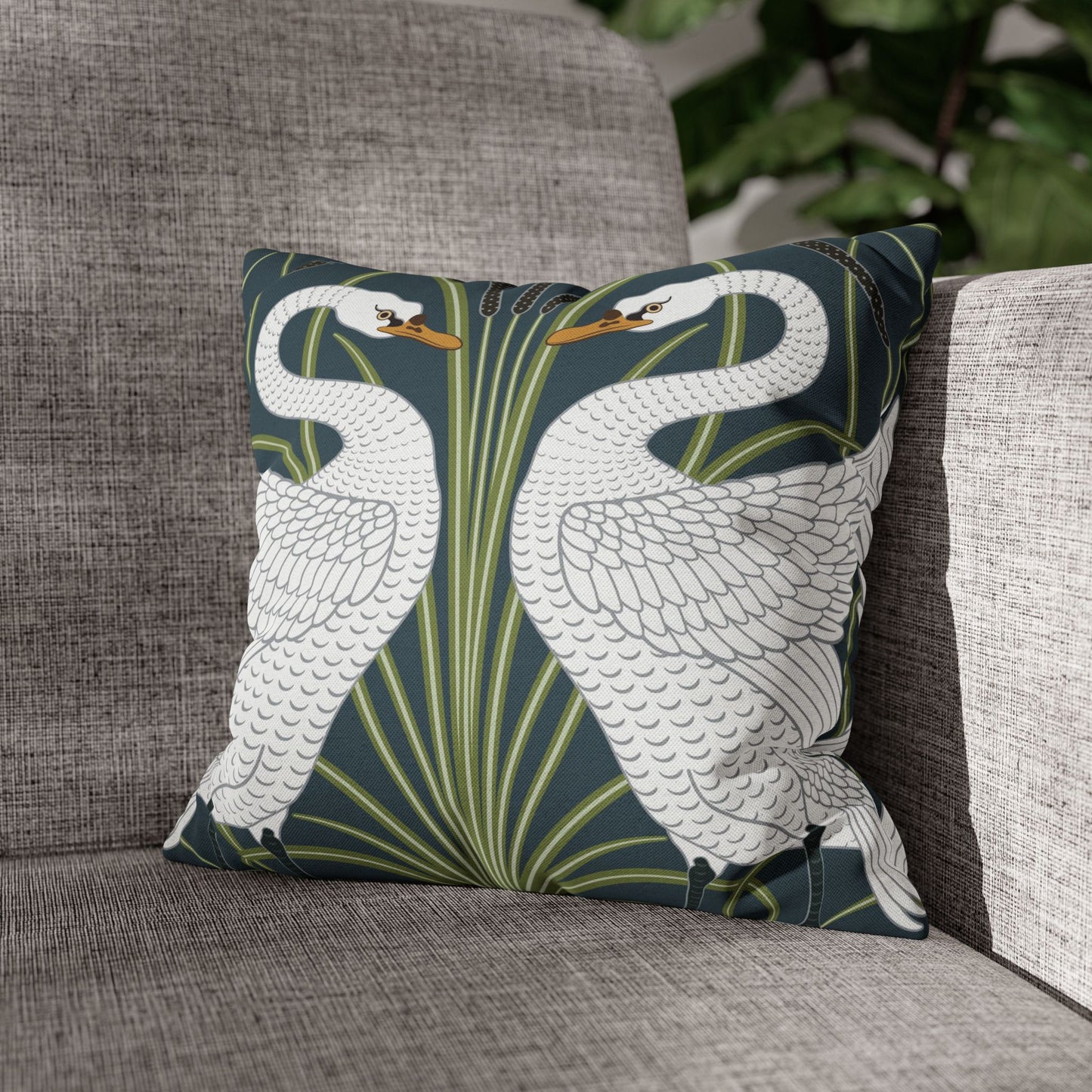 Decorative pillows with swan design on a gray couch