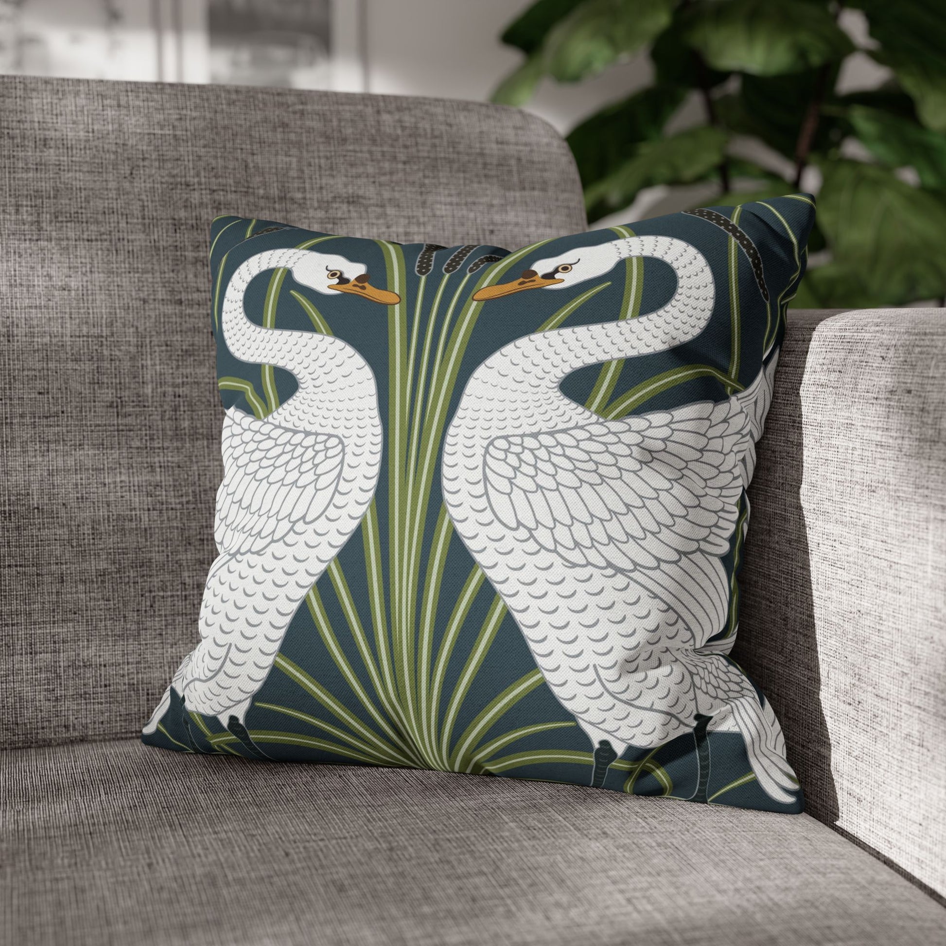 Decorative pillow with swan design on a gray sofa