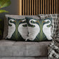 Decorative pillows with swan design on a gray sofa against a wooden panel background