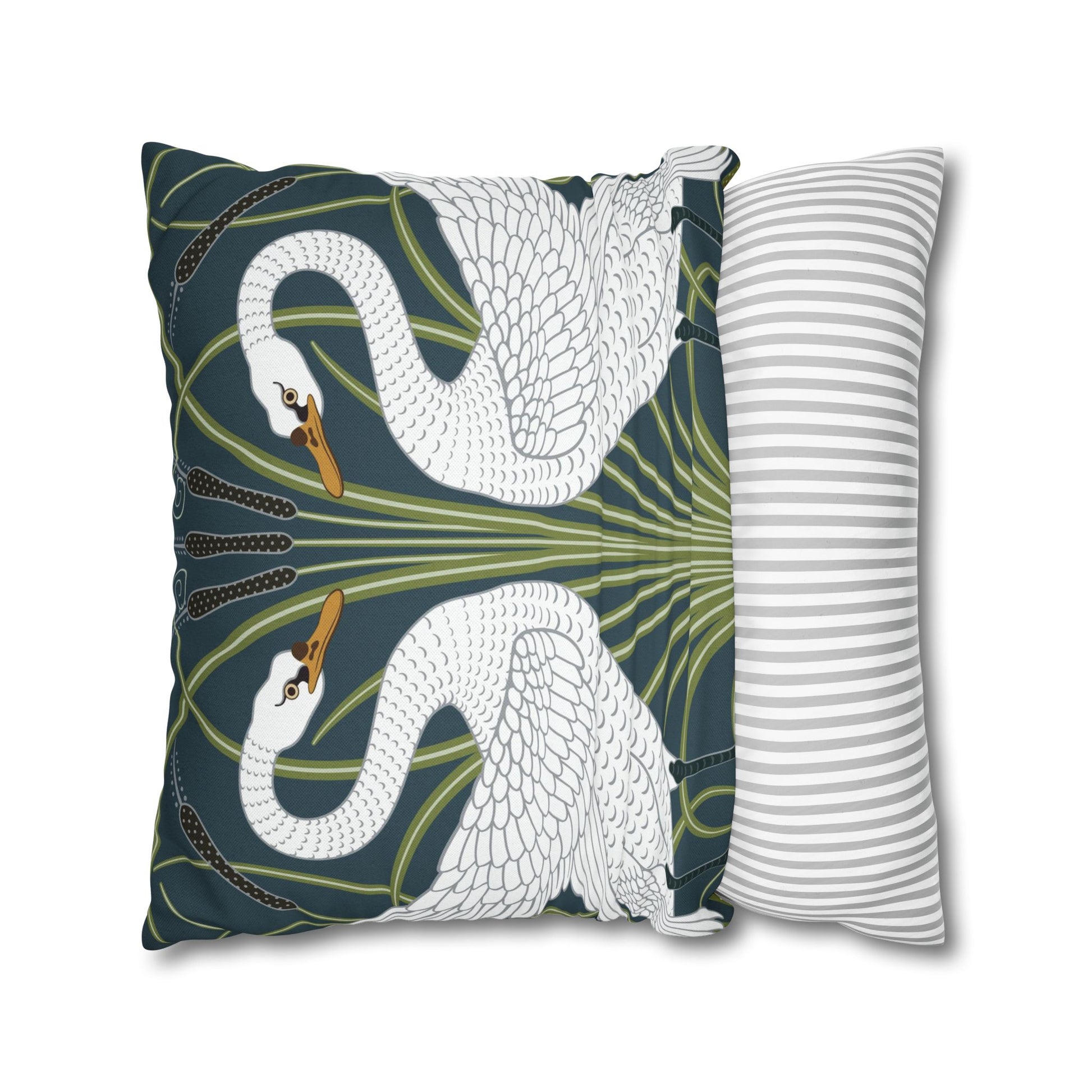 Decorative pillow with swan design next to a striped pillow on a white background