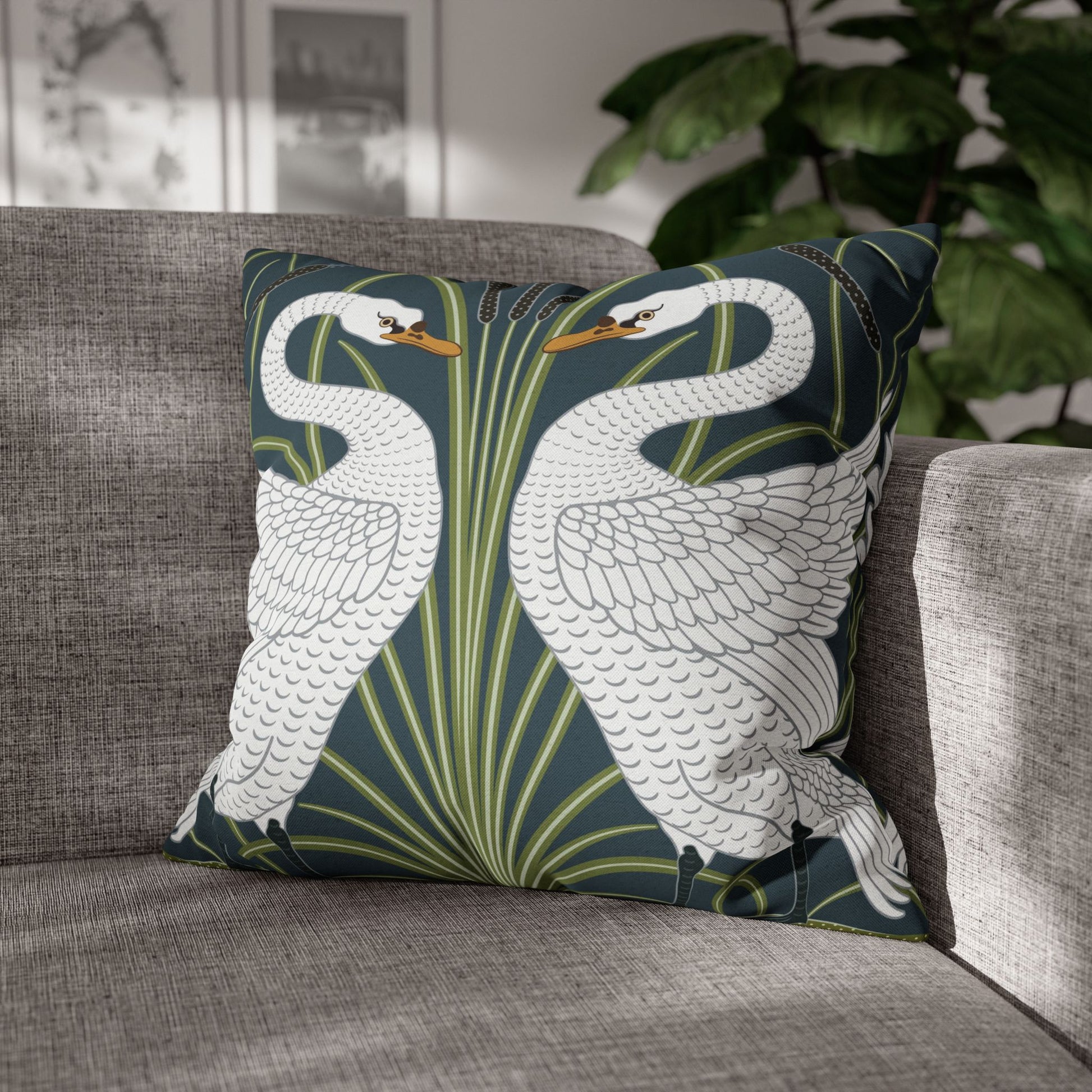 Decorative pillow with swan design on a gray sofa