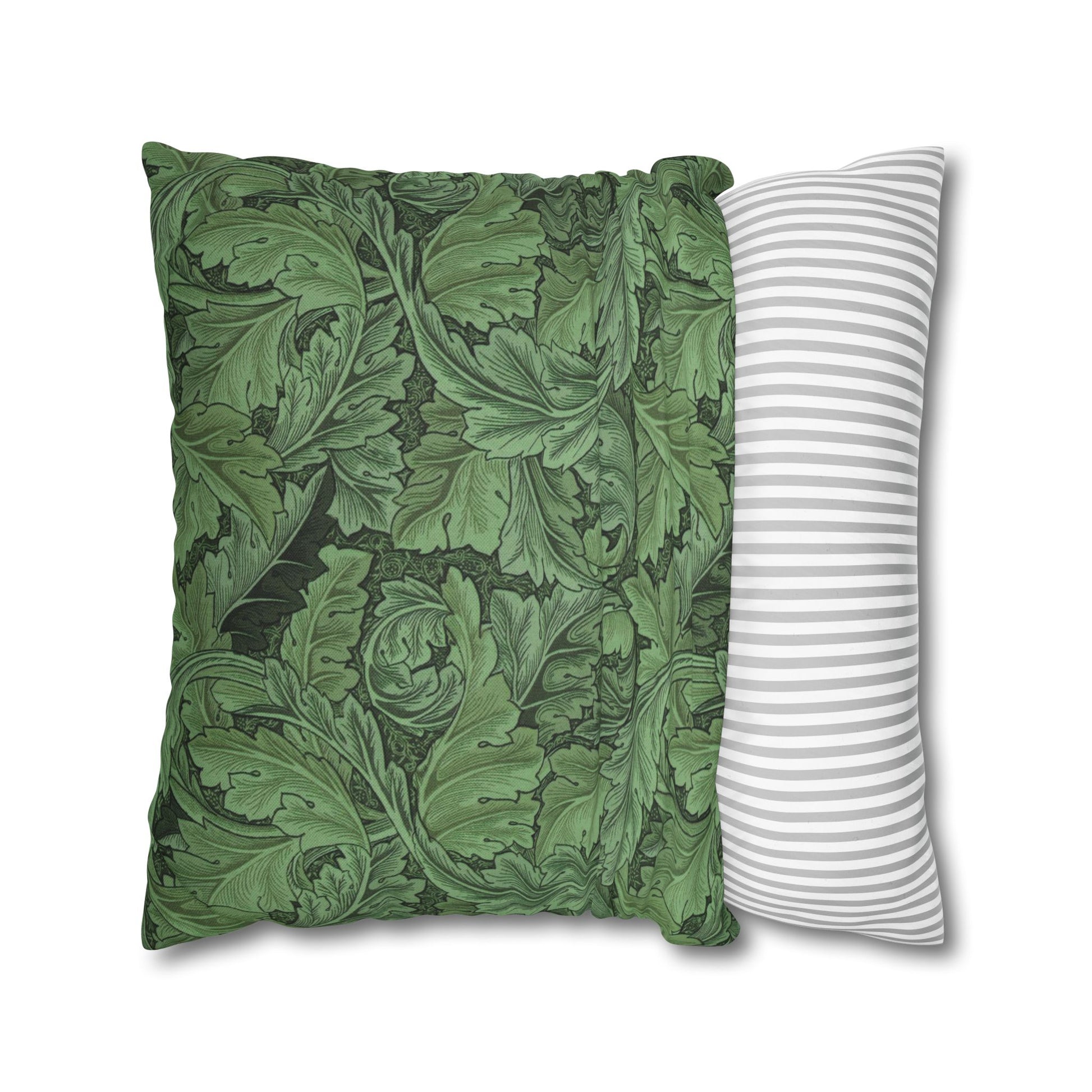 Two pillows, one with green leaf pattern and one with white stripes, on a white background.