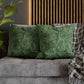 Green patterned pillows on a gray sofa with a wooden slat wall in the background