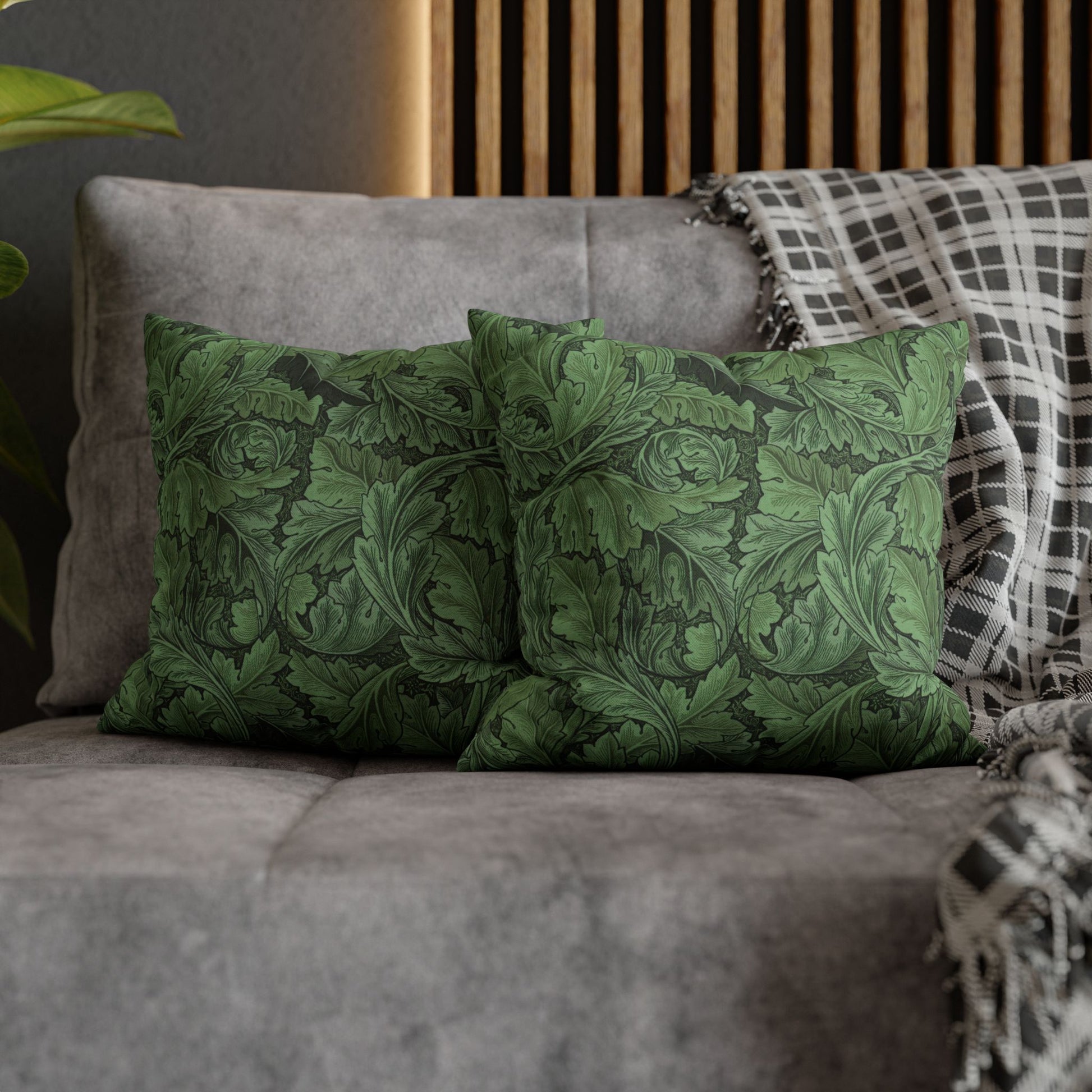 Green patterned cushions on a gray sofa with a wooden headboard in the background