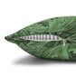 Green decorative pillow with black leaf pattern and a feather on a white background