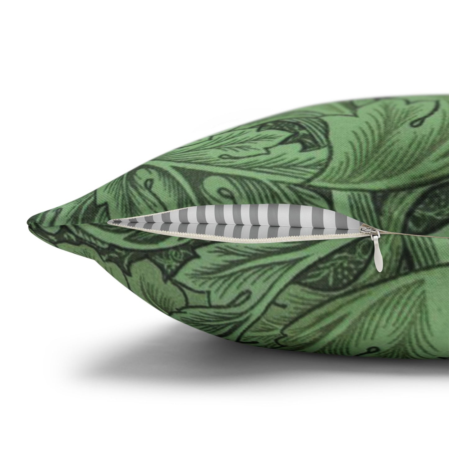 Green patterned pillow with a zipper and feather on a white background