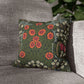 Floral patterned pillow on a gray sofa with a blurred green plant in the background