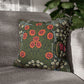 Floral patterned pillow on a gray sofa with a blurred plant in the background