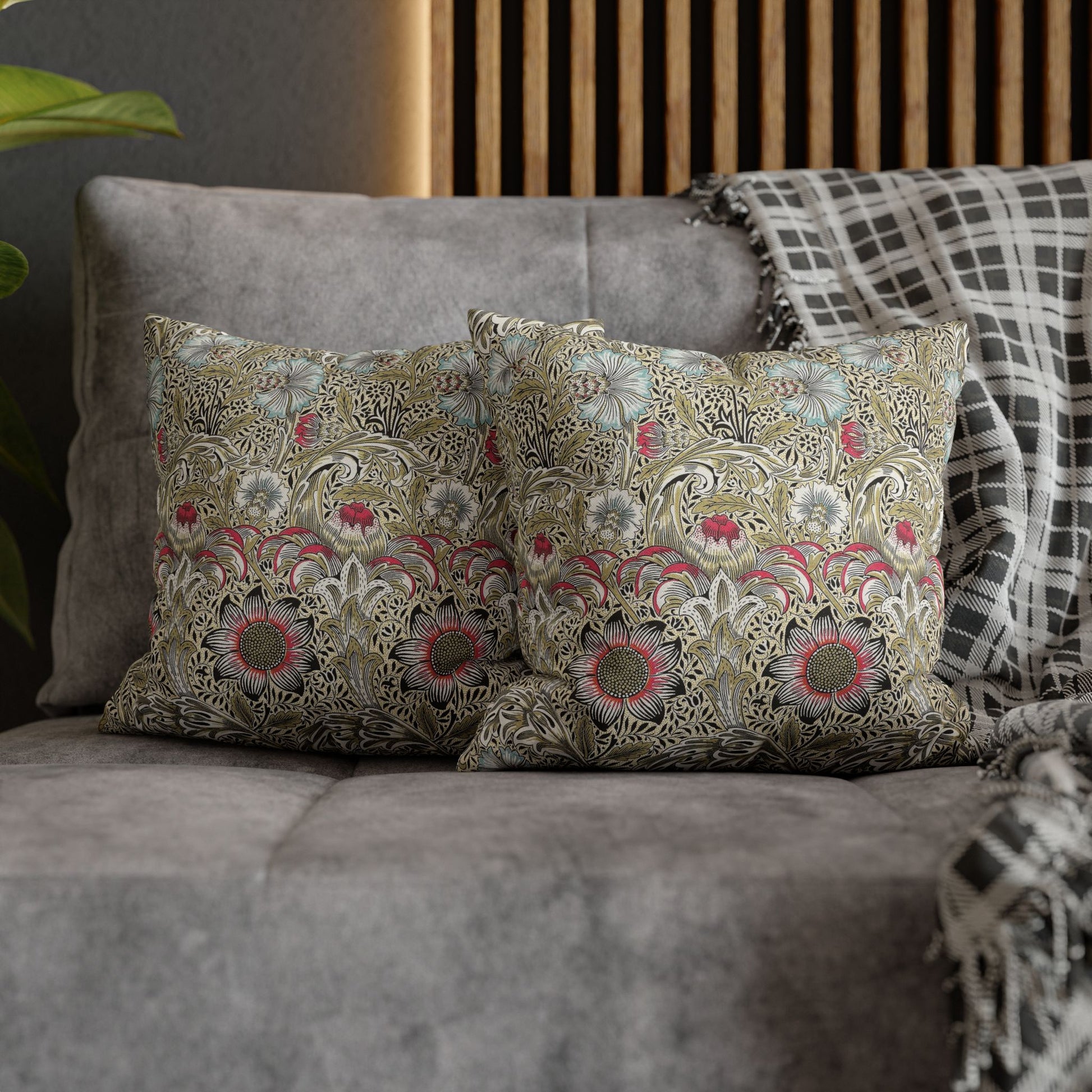 Decorative pillows with floral patterns on a gray sofa.
