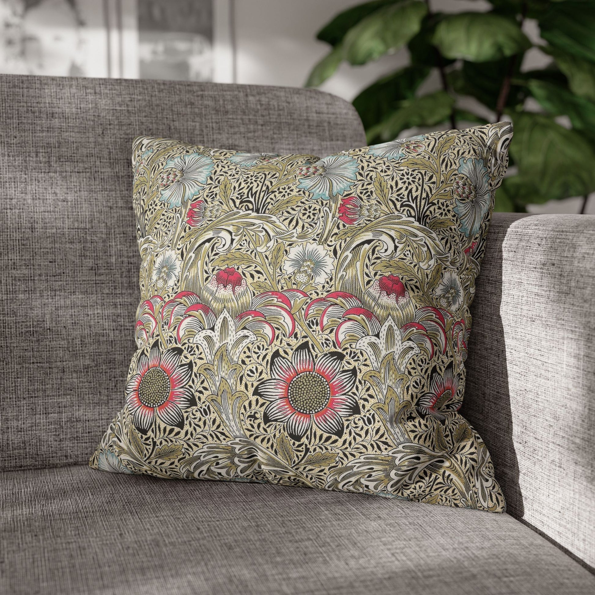 Decorative floral pillow on a gray sofa with a blurred indoor background