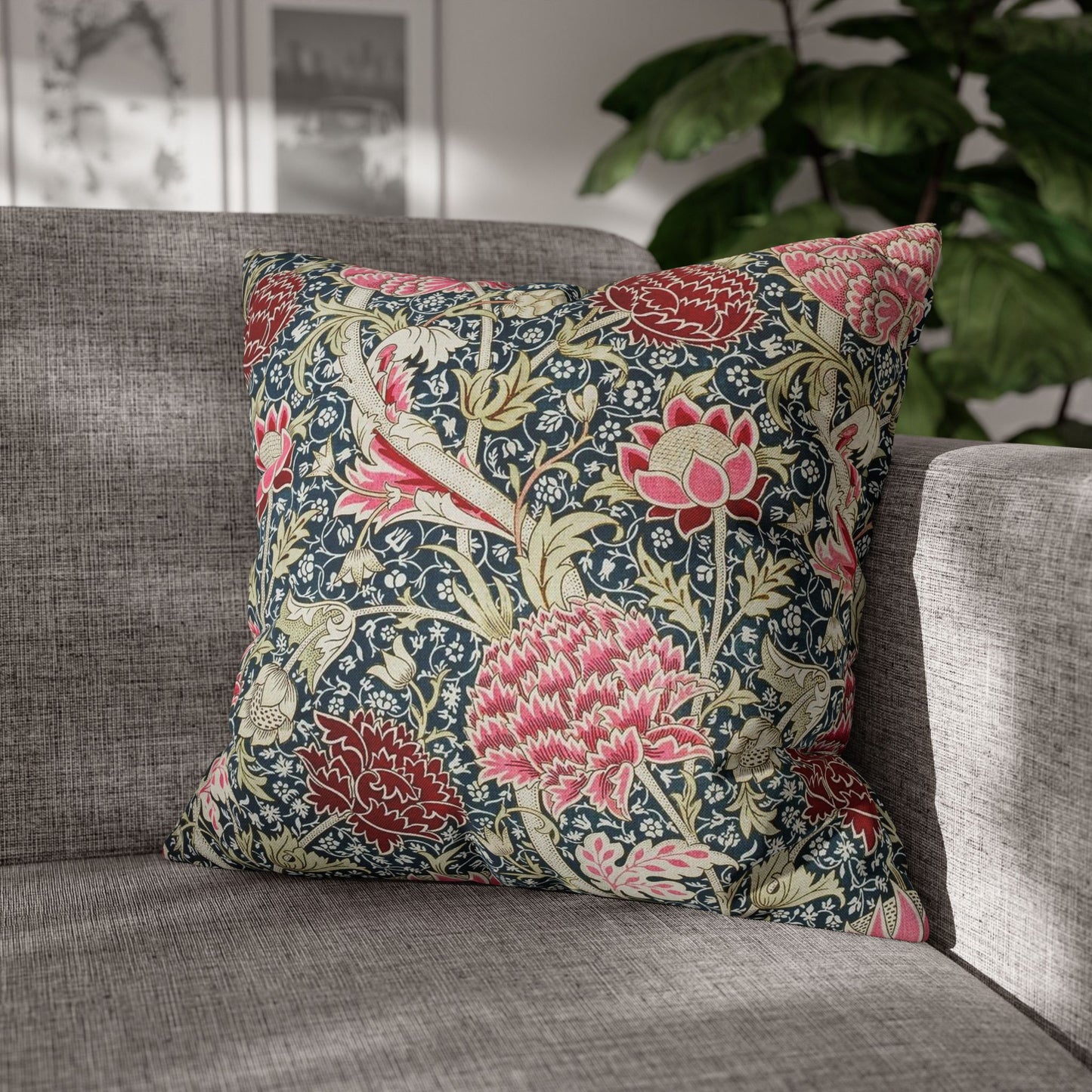 Decorative floral pillow on a gray sofa with a blurred indoor background