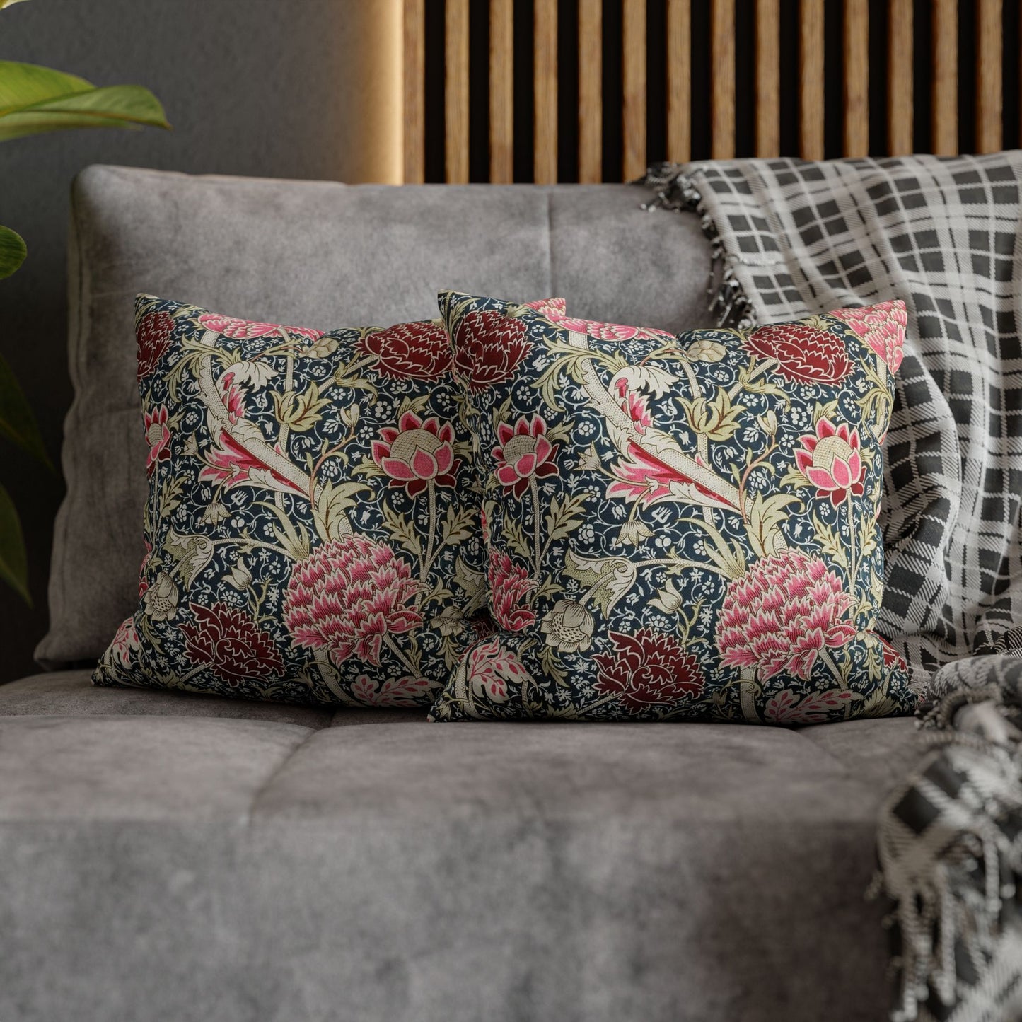 Floral patterned cushions on a gray sofa with a wooden headboard in the background.
