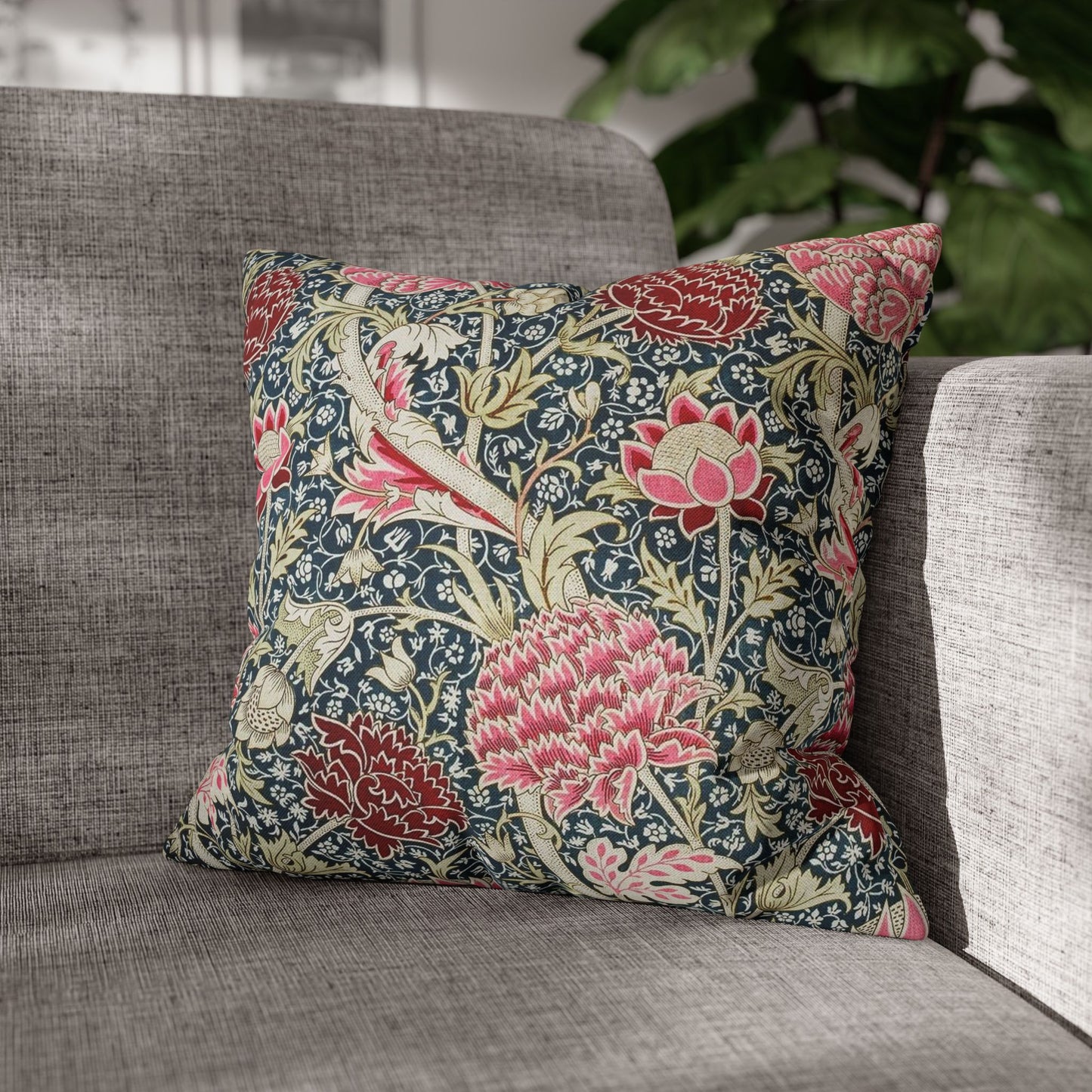 Floral patterned pillow on a gray sofa with a blurred background