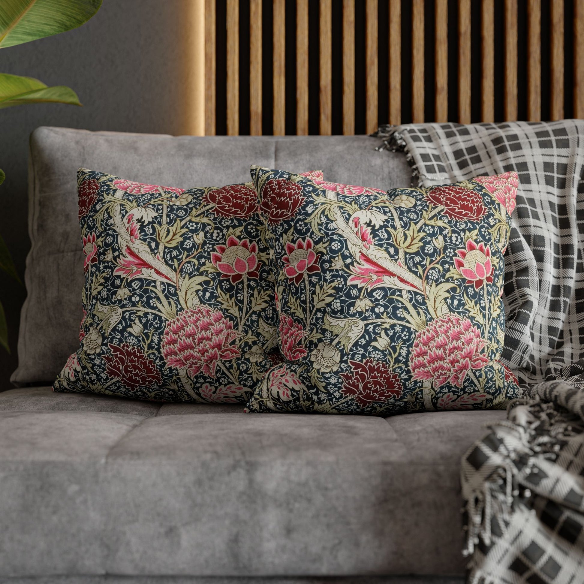 Floral patterned cushions on a gray sofa with a wooden headboard in the background.