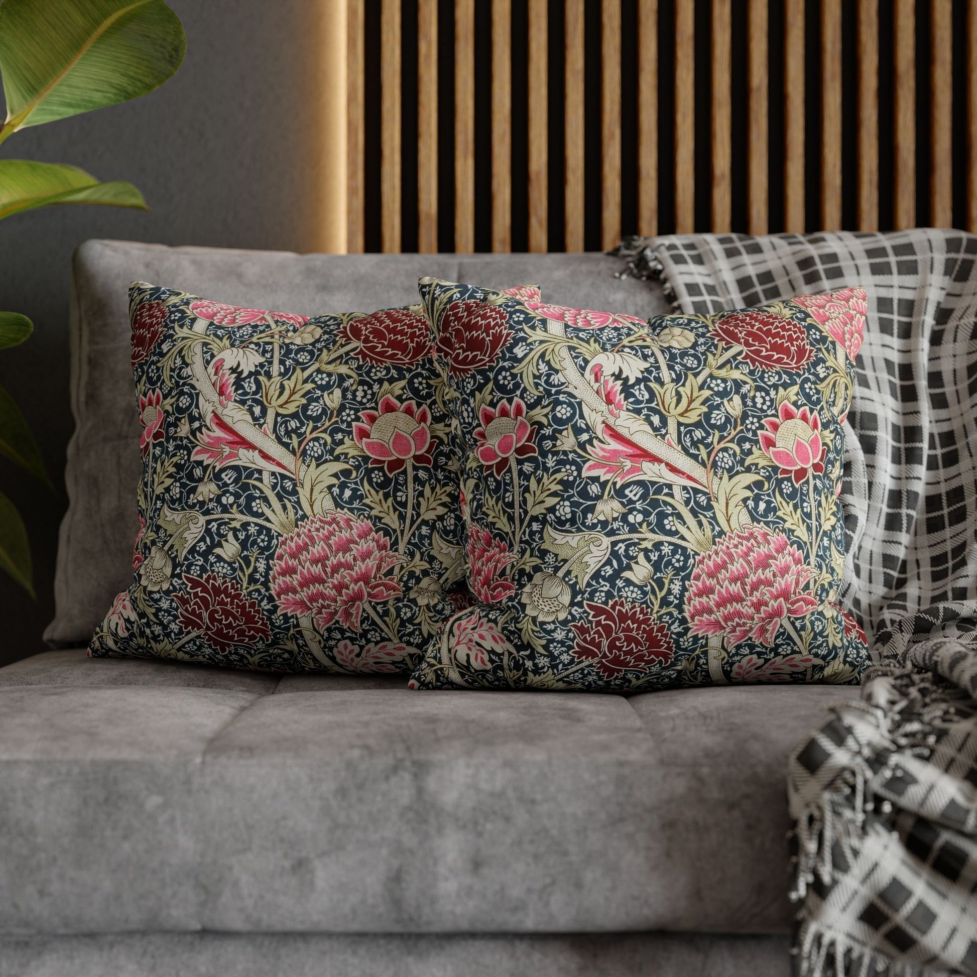Floral patterned cushions on a gray sofa with a wooden headboard in the background.