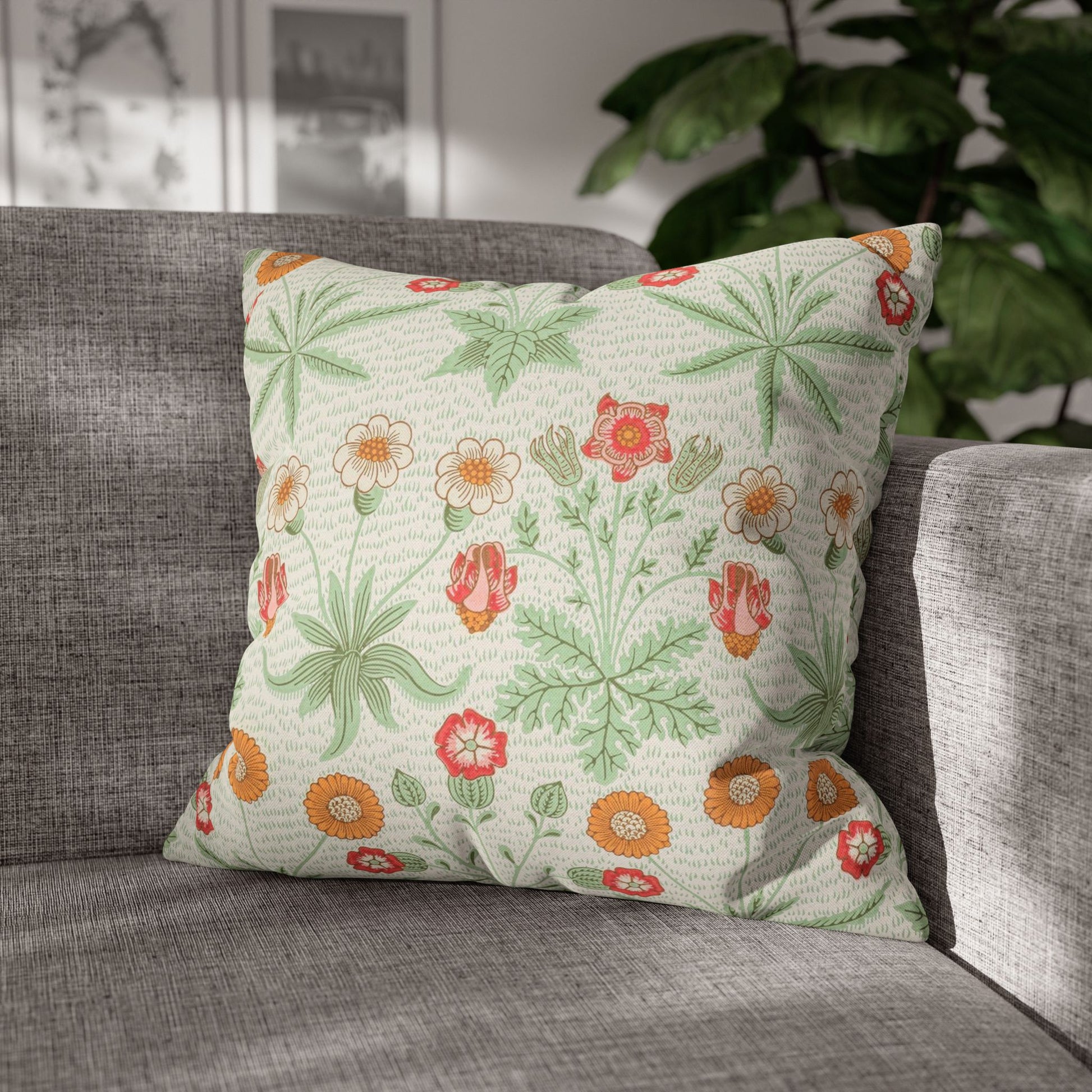 Floral patterned pillow on a gray sofa with a blurred indoor background