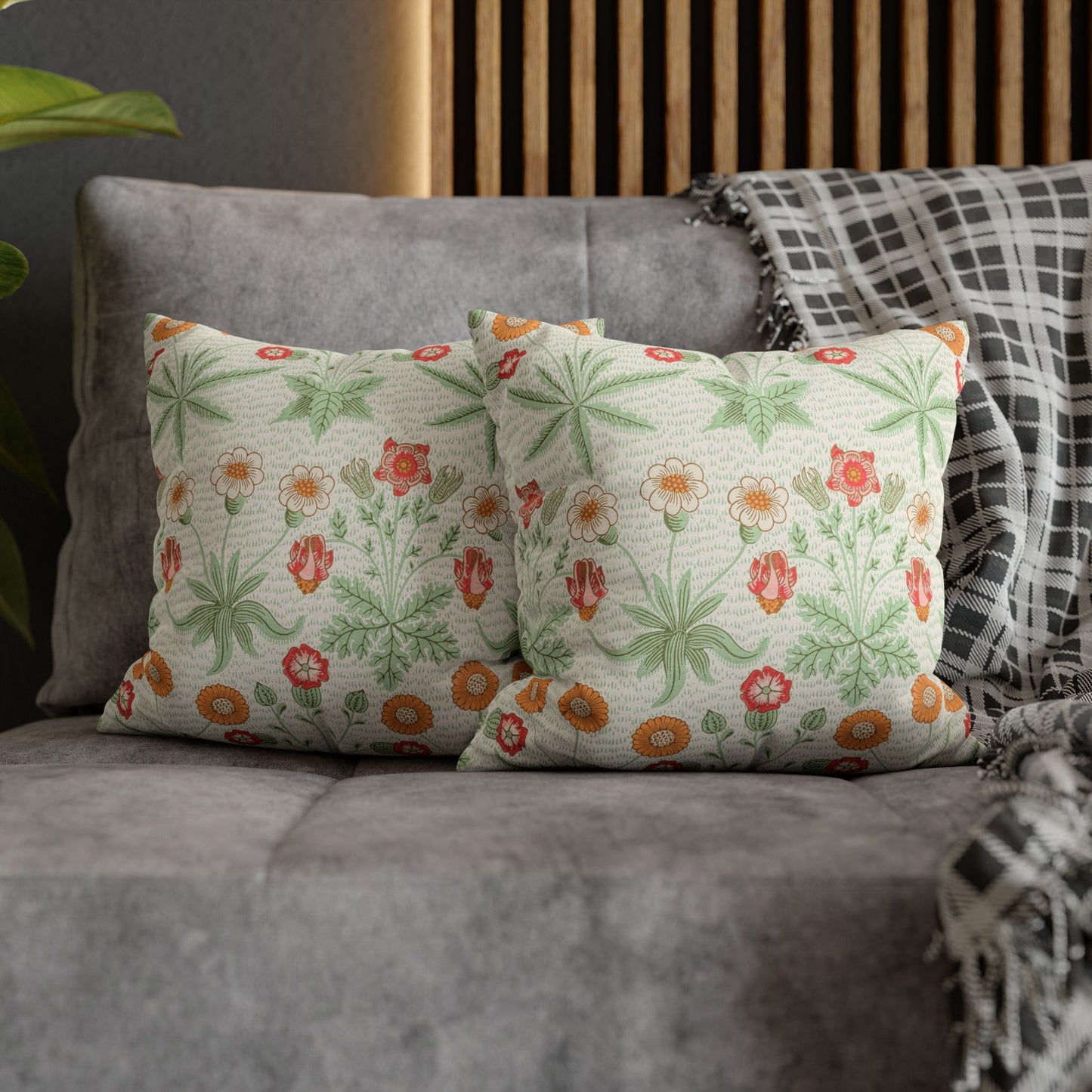 Floral-patterned cushions on a gray sofa with a wooden headboard in the background.