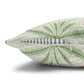 Green leaf-patterned pillow with a zipper on a white background