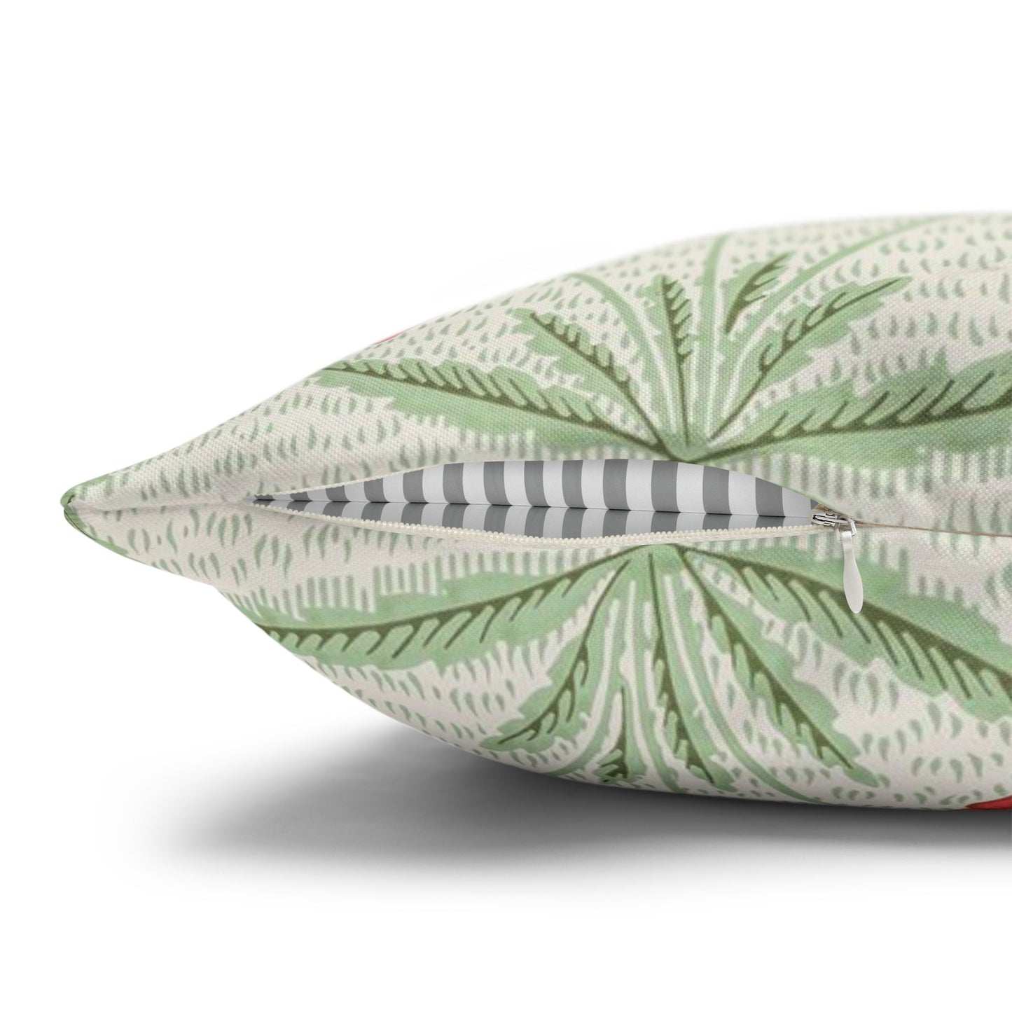 Green leaf-patterned pillow with a zipper on a white background