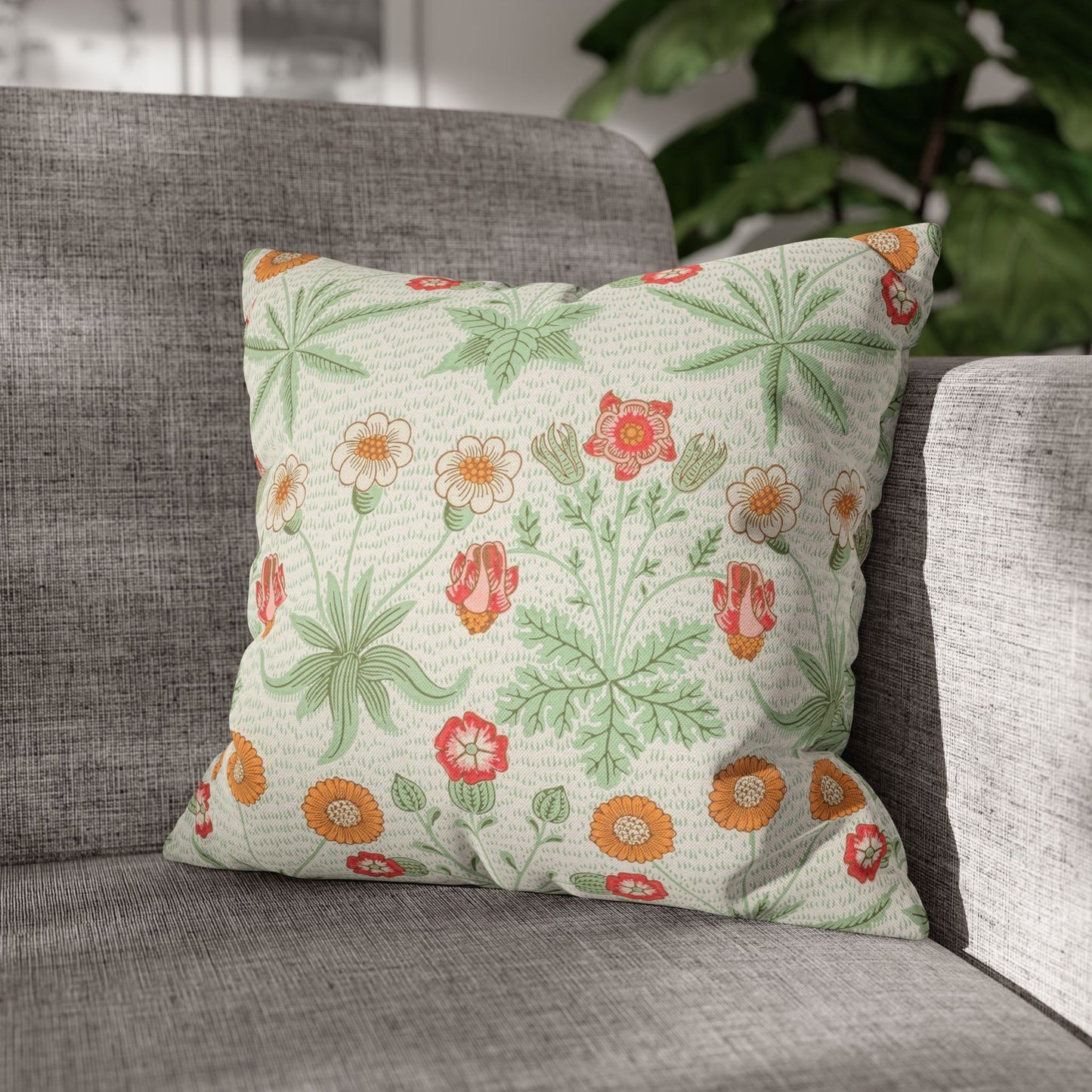 Floral patterned pillow on a gray sofa with a blurred background