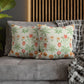 Floral patterned cushions on a gray sofa with a wooden headboard in the background.