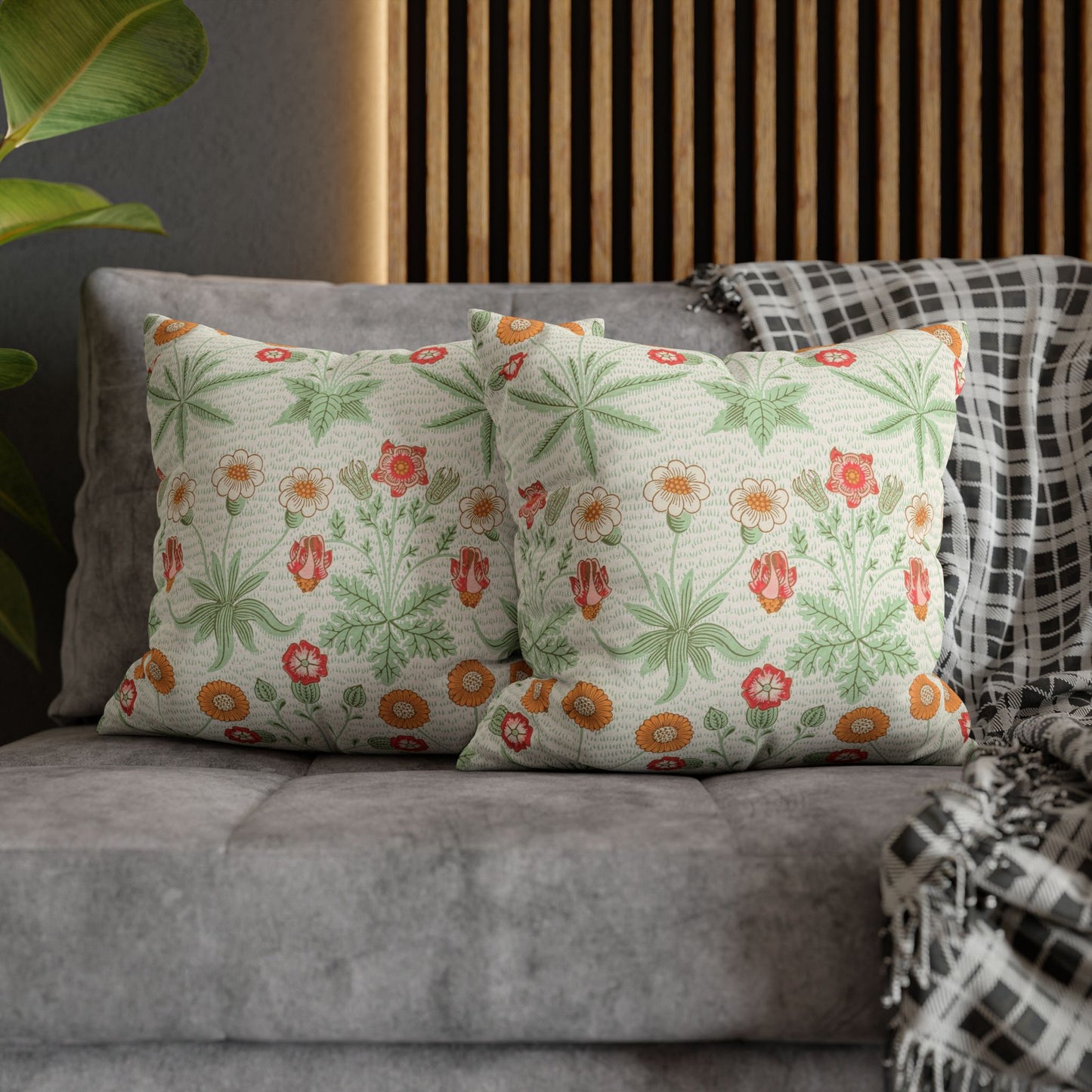 Floral patterned cushions on a gray sofa with a wooden headboard in the background.