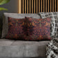 Decorative pillows with intricate patterns on a gray sofa against a wooden headboard.